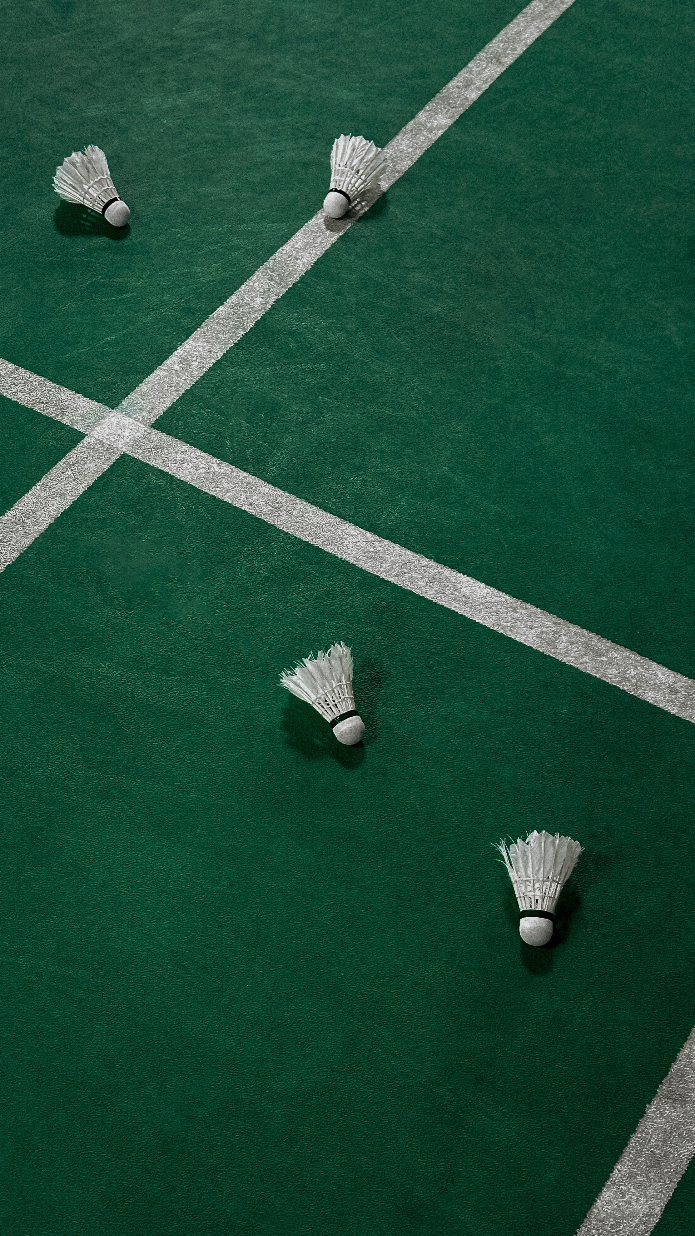 A tennis court with three white shoes on it