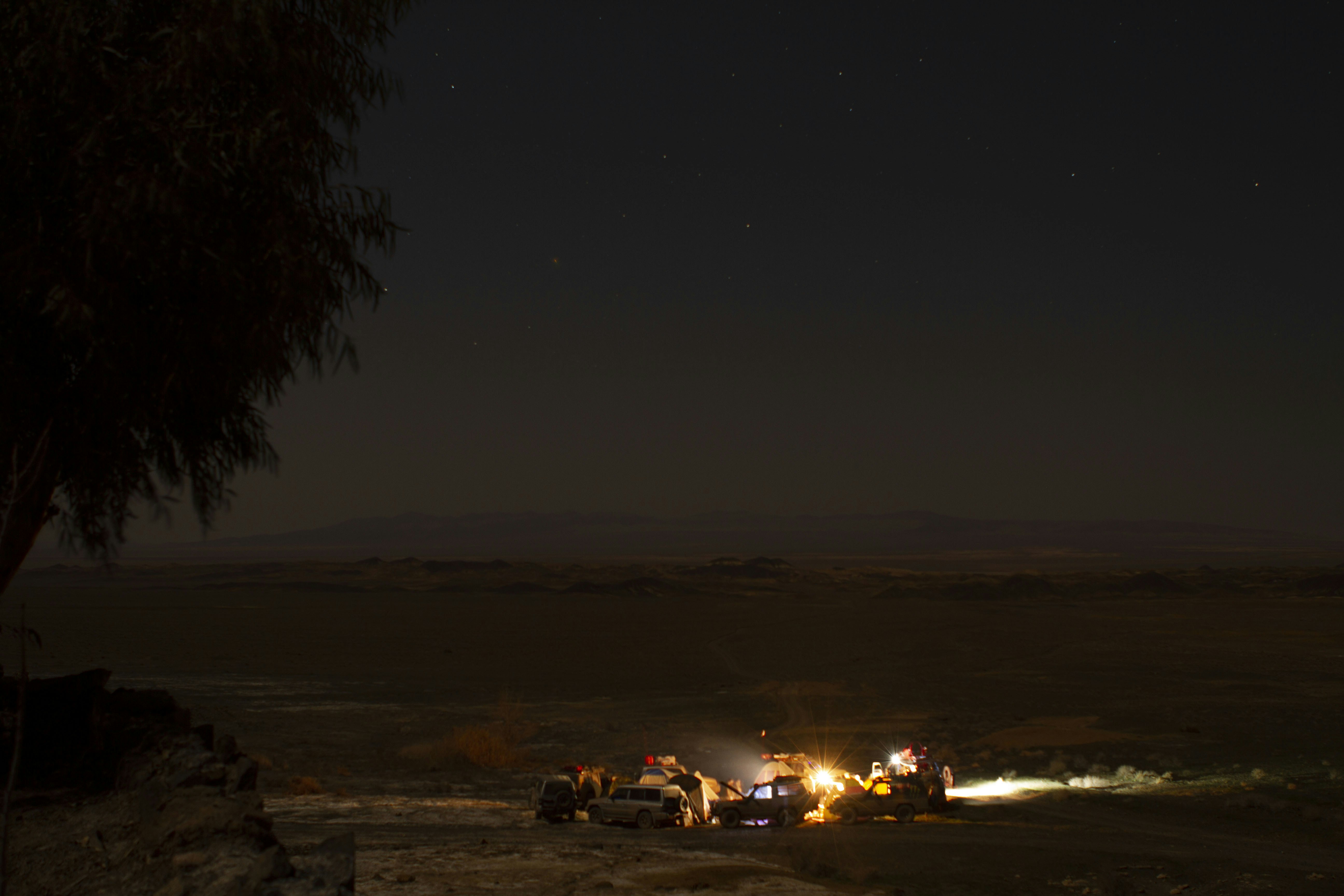 A group of people standing on top of a hill at night