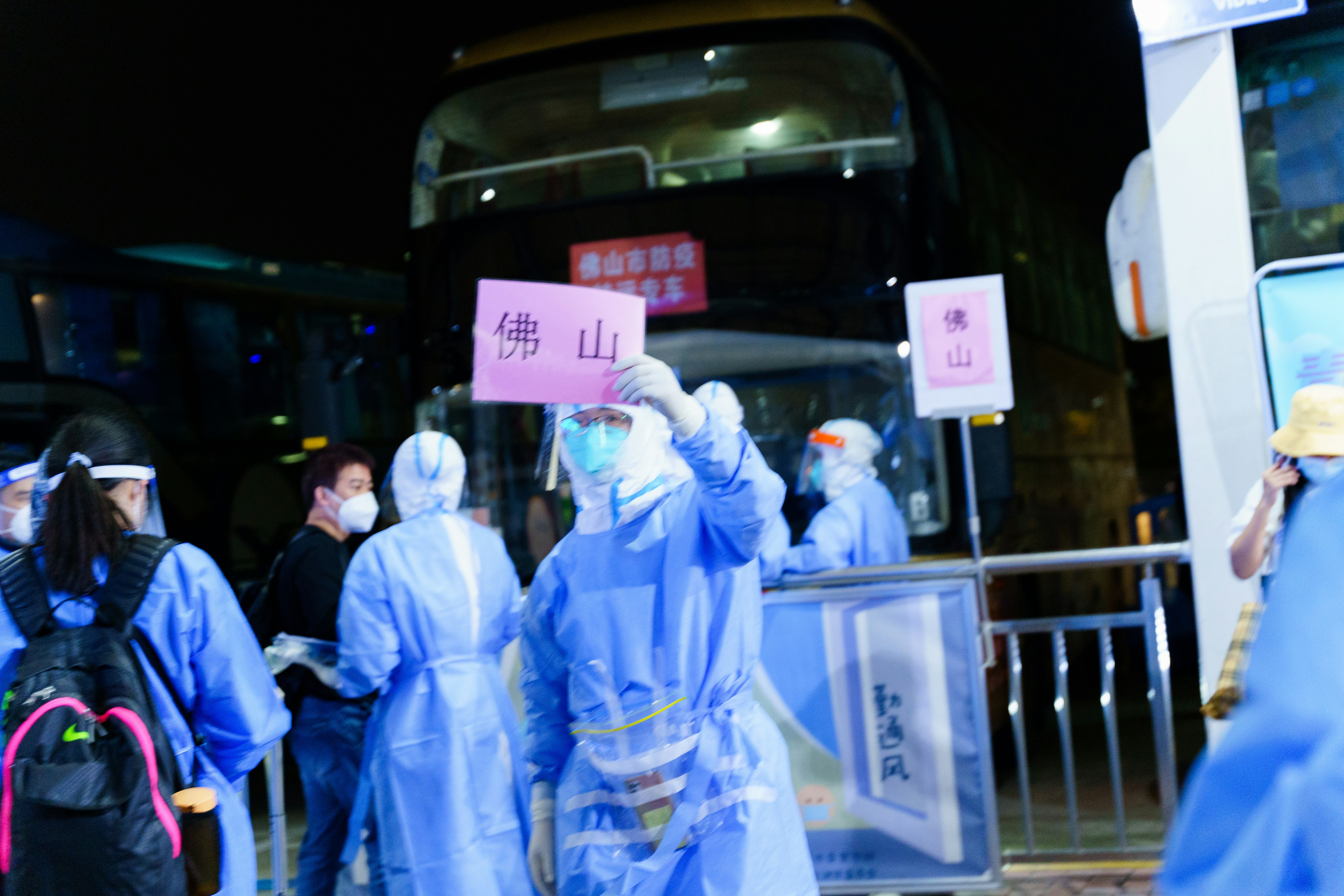 A group of people standing around a bus