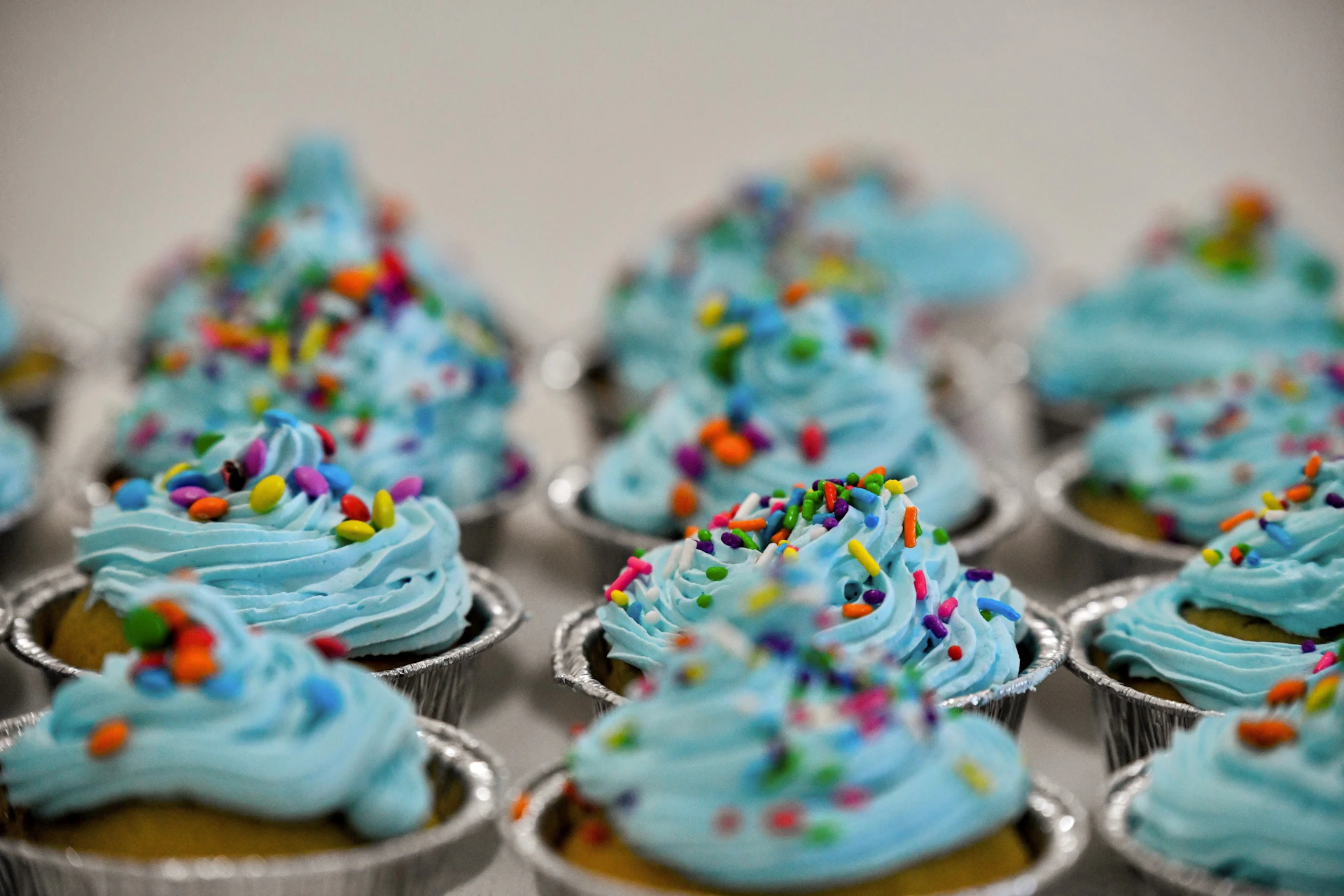 A close up of cupcakes with blue frosting and sprinkles