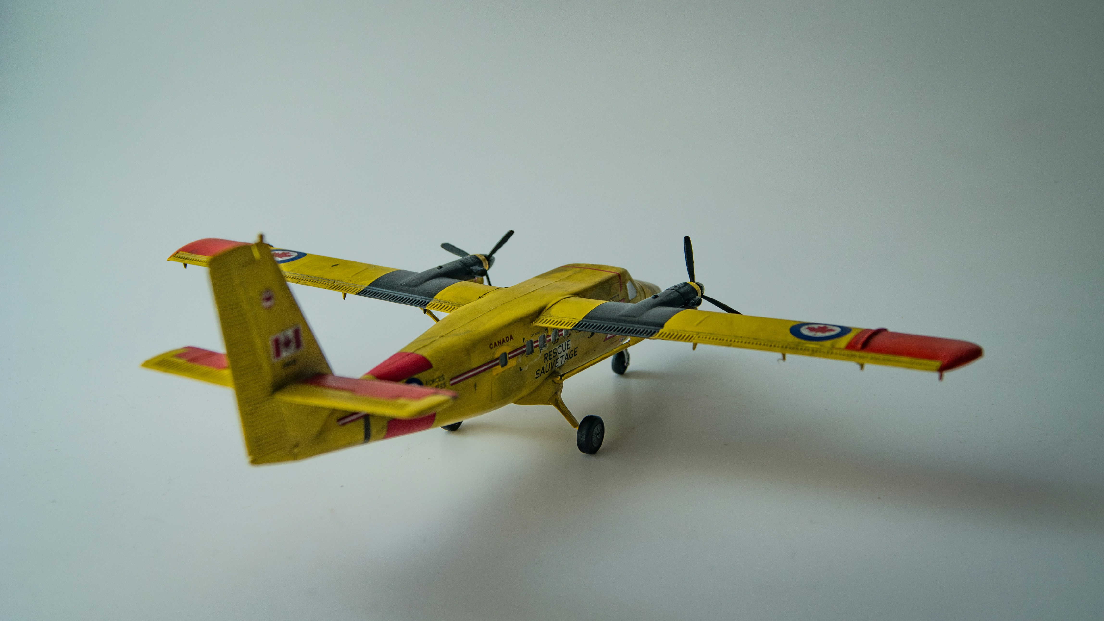 A yellow and red model airplane on a white surface, 