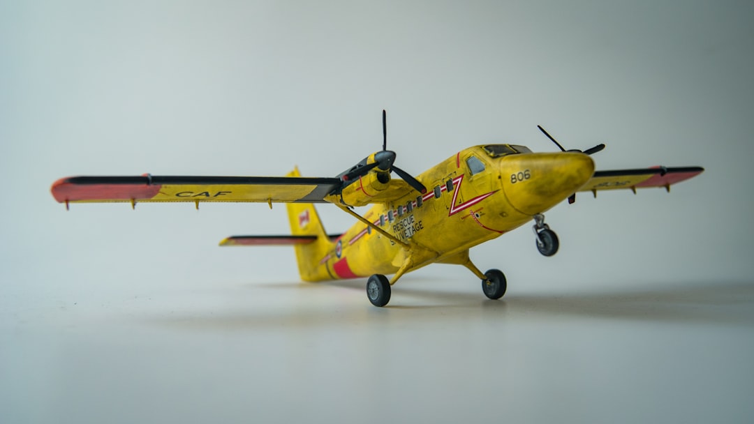 A small yellow airplane on a white surface,