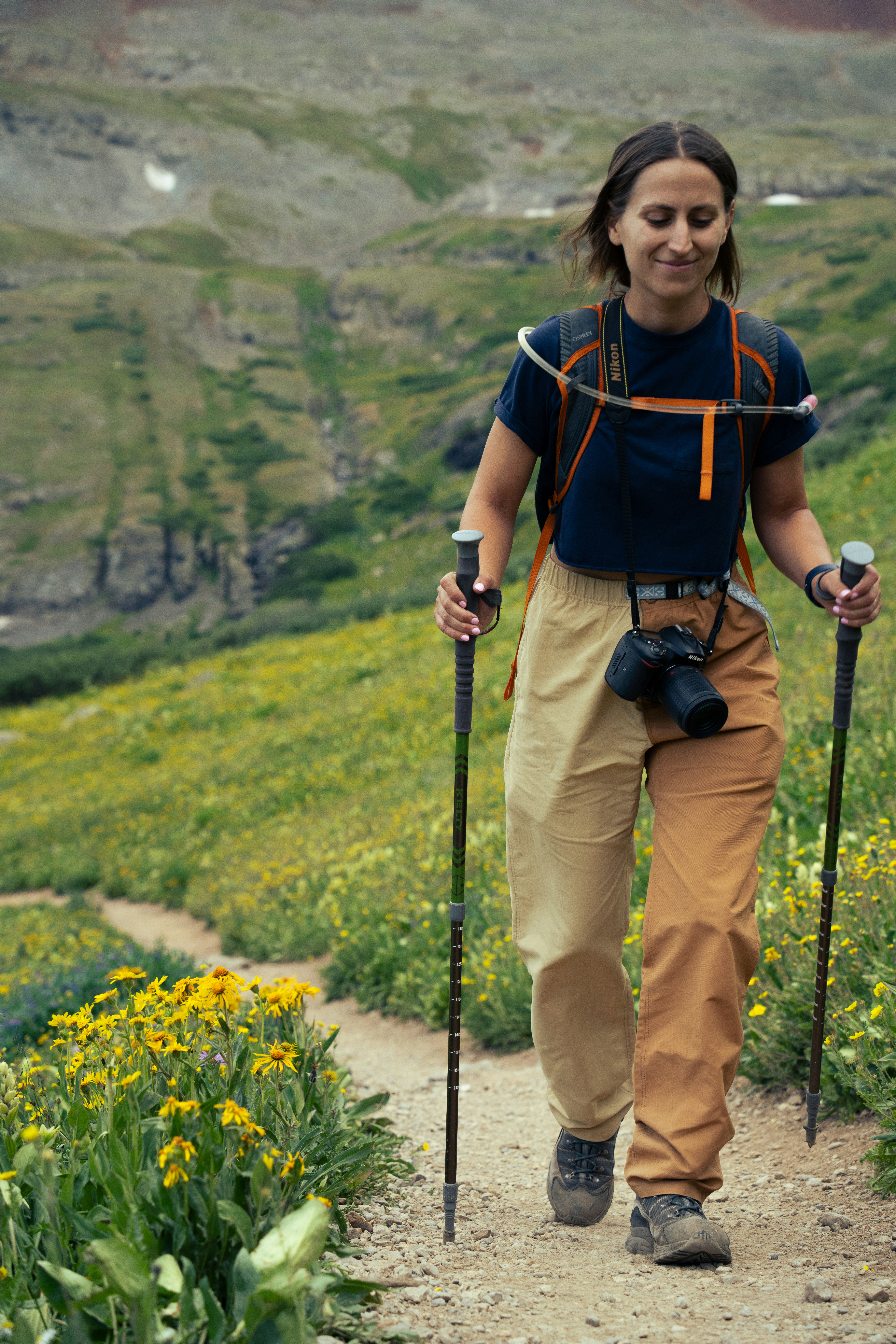 A woman hiking up a trail in the mountains
