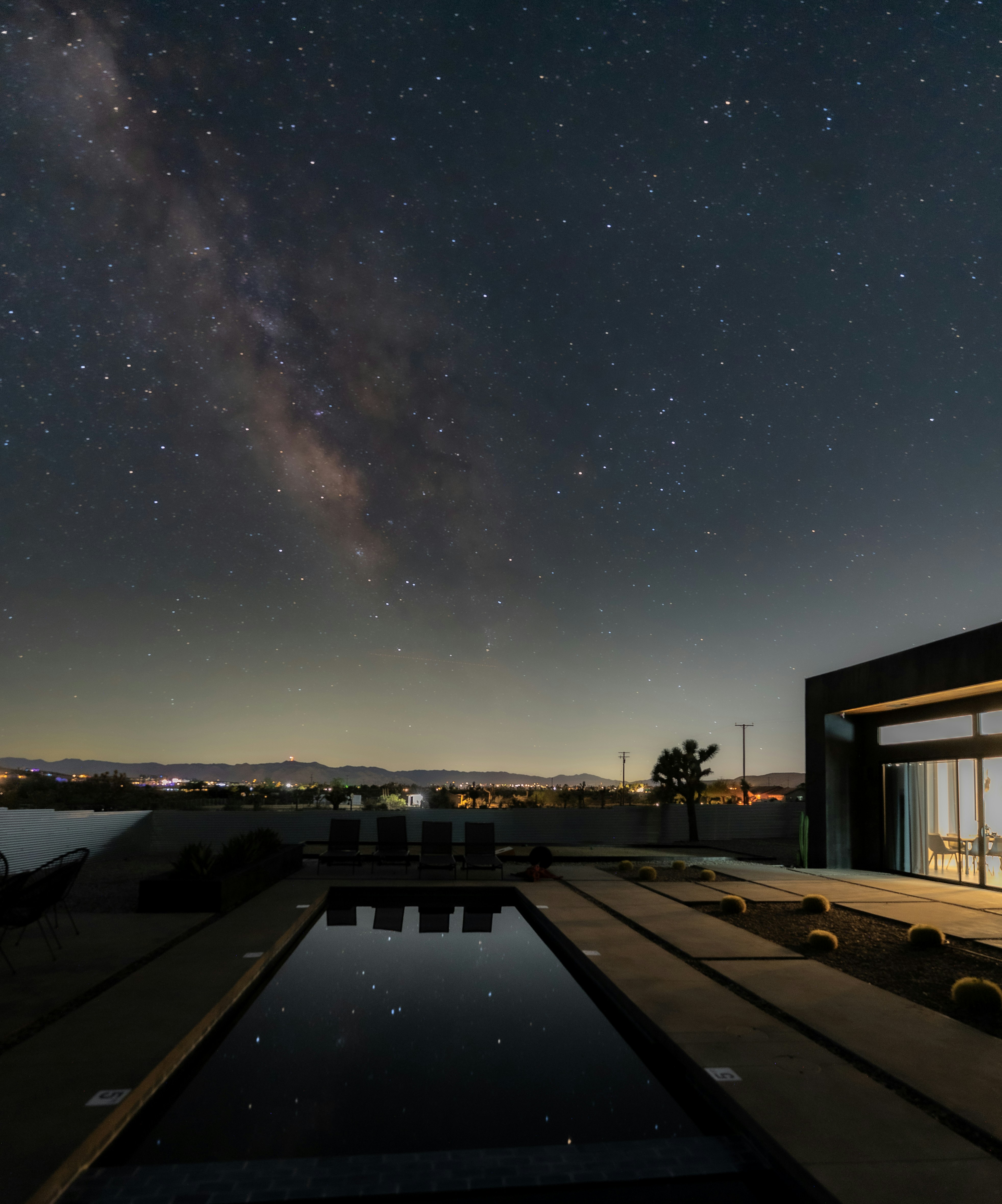 A view of the night sky with a pool in the foreground
