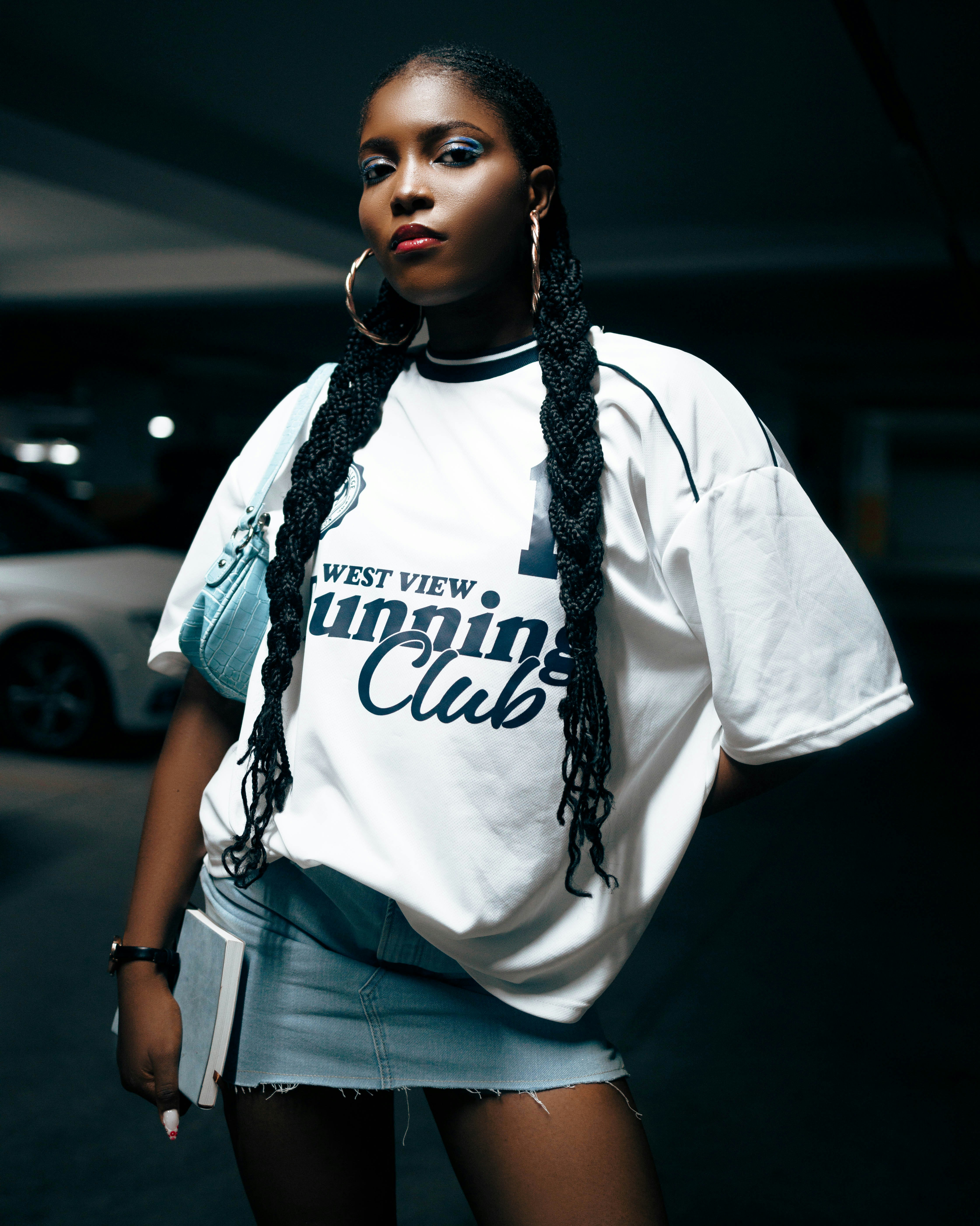 A woman standing in a parking garage wearing a white shirt