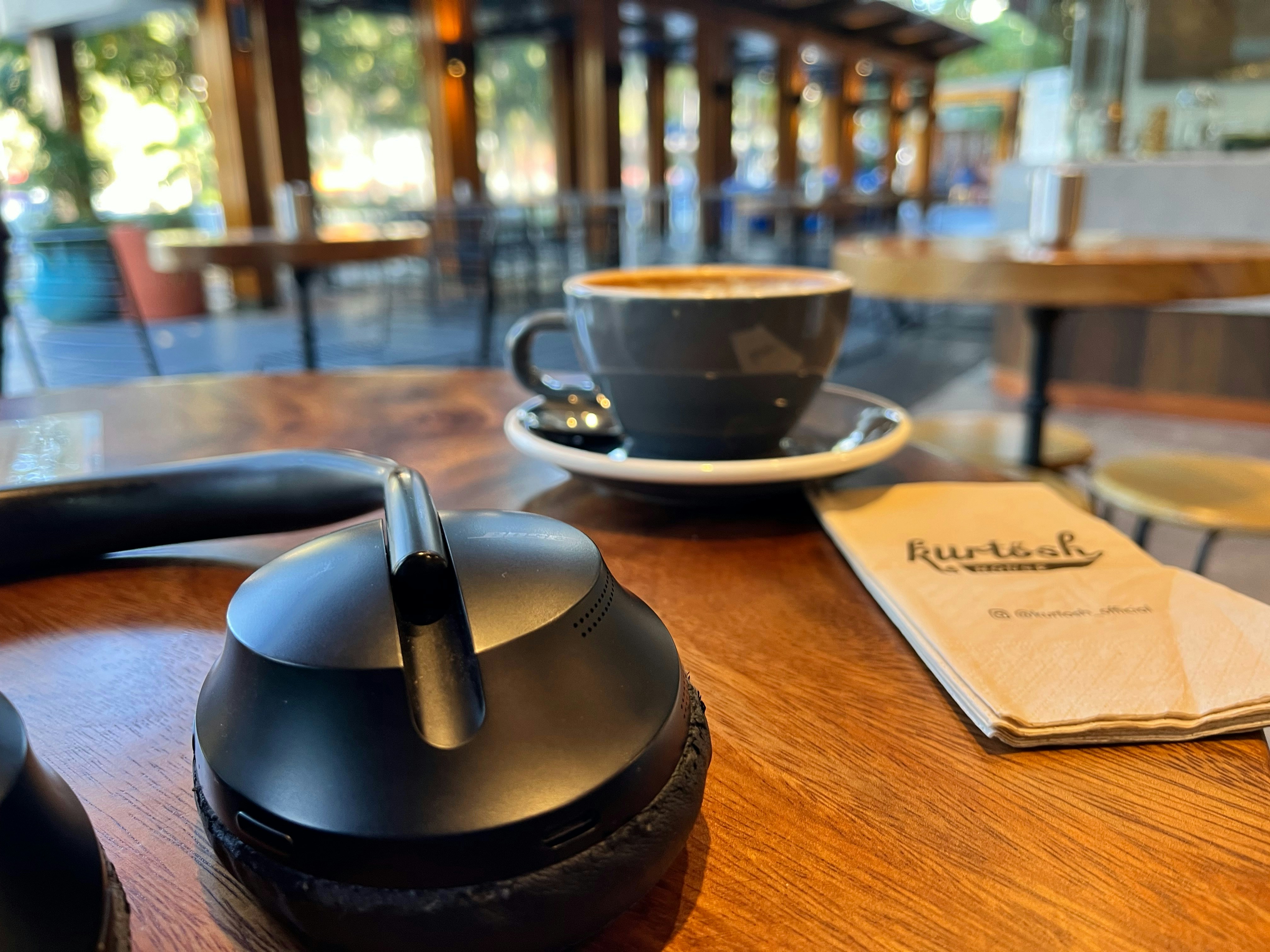 A wooden table topped with a cup of coffee