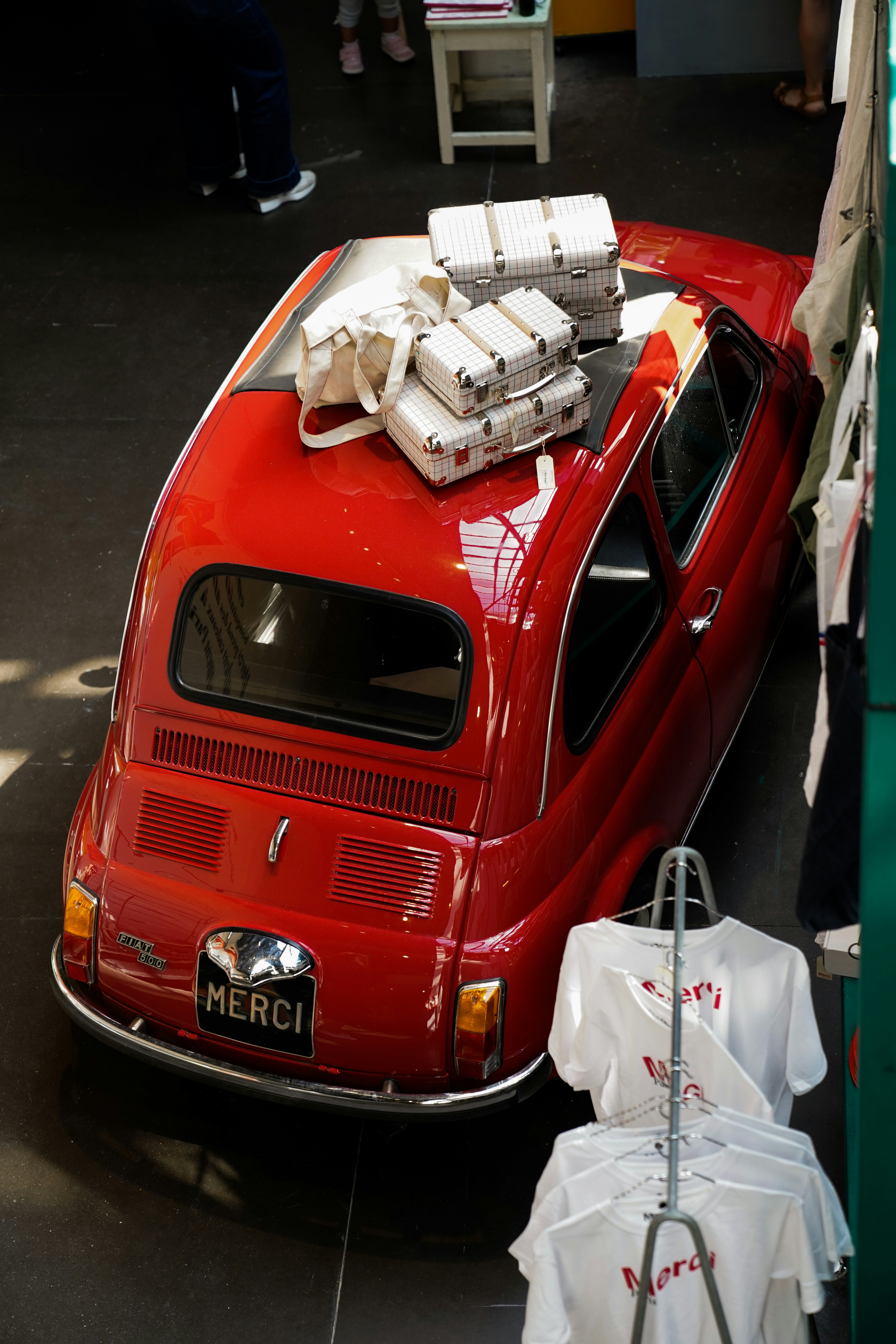 A red car with a bunch of luggage on top of it