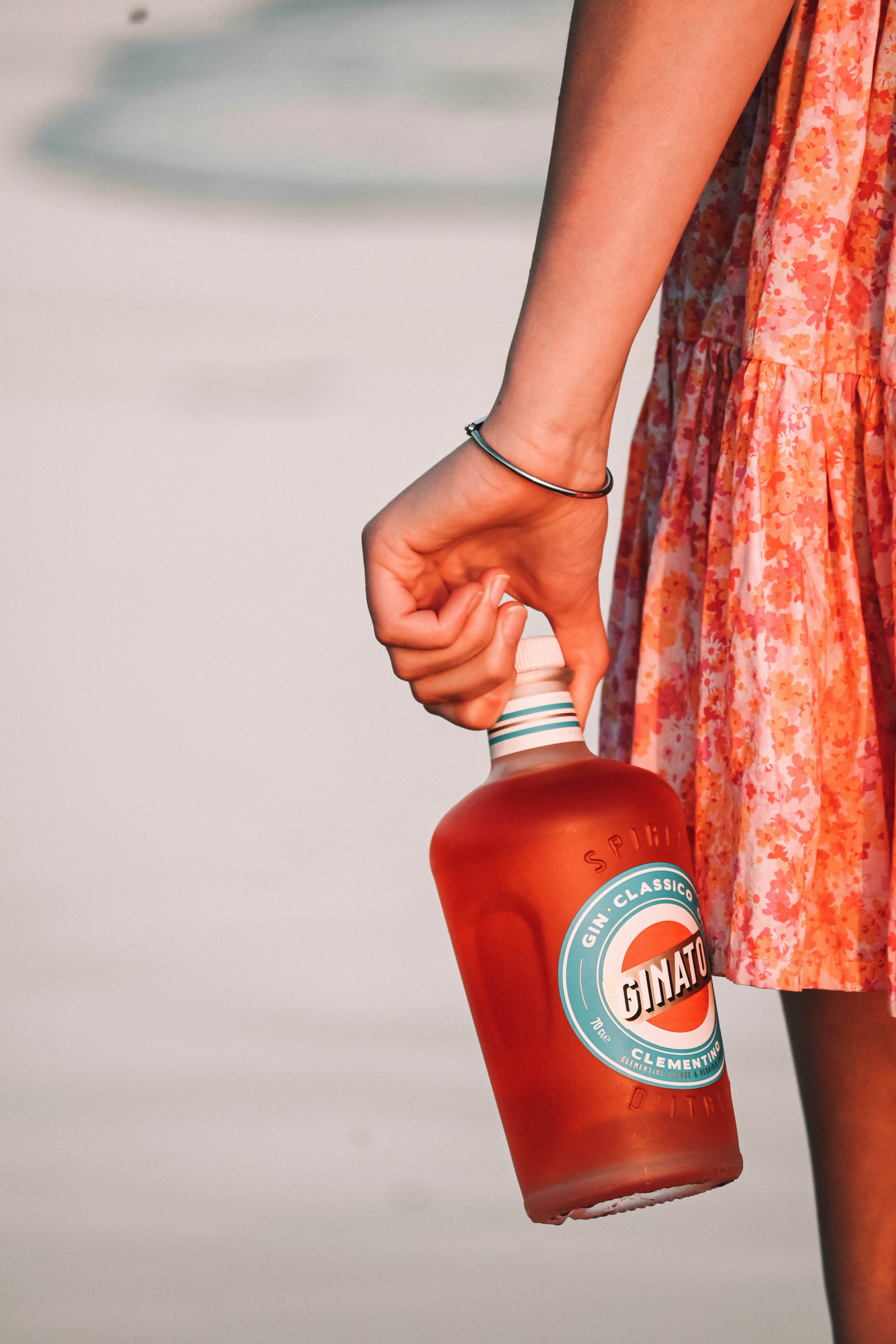 A woman holding a bottle of orange juice