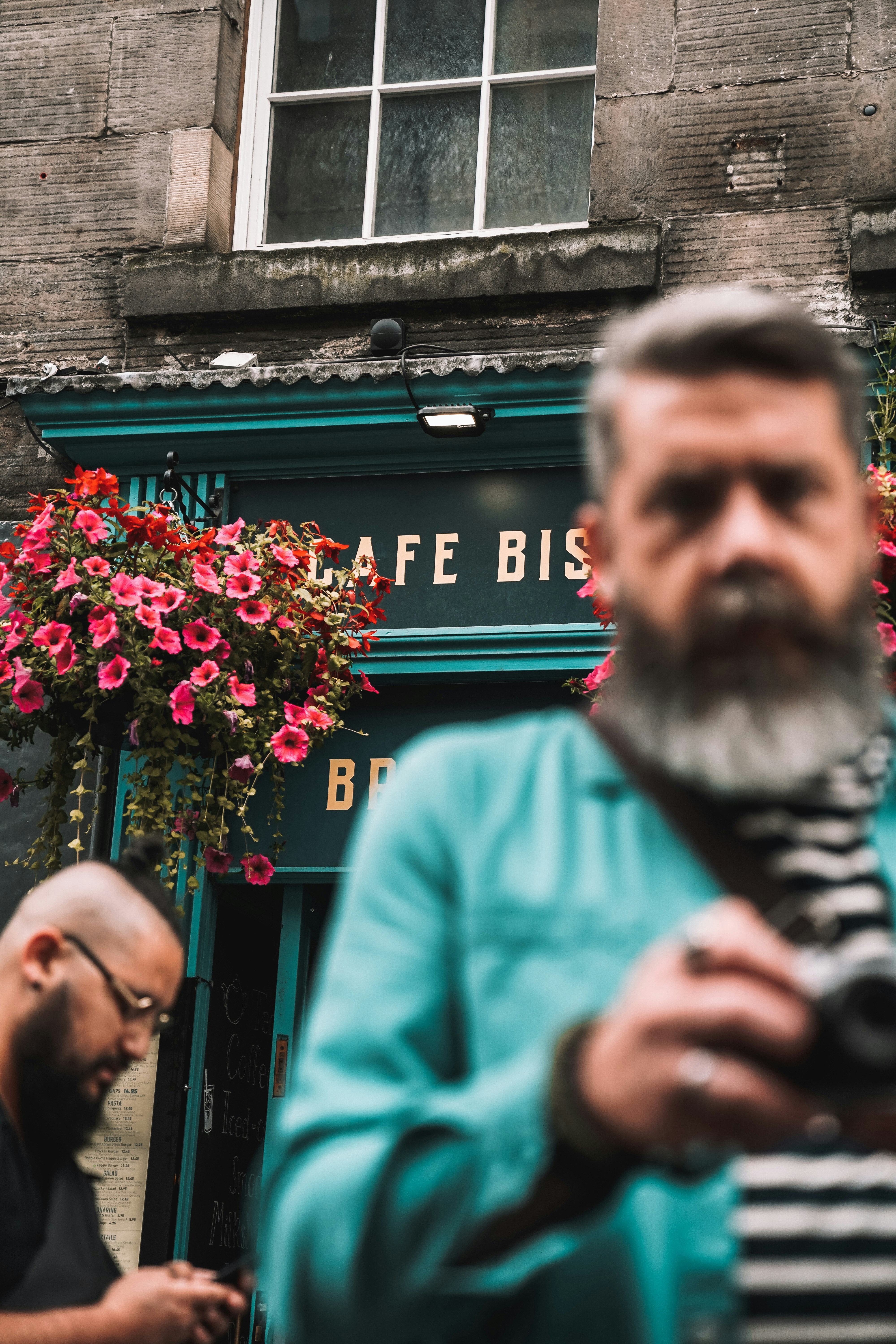 A man standing in front of a building holding a camera