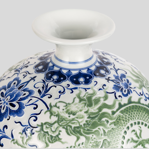 A blue and green vase with a dragon on it