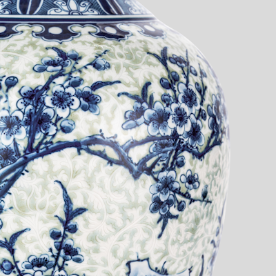 A blue and white vase with flowers on it