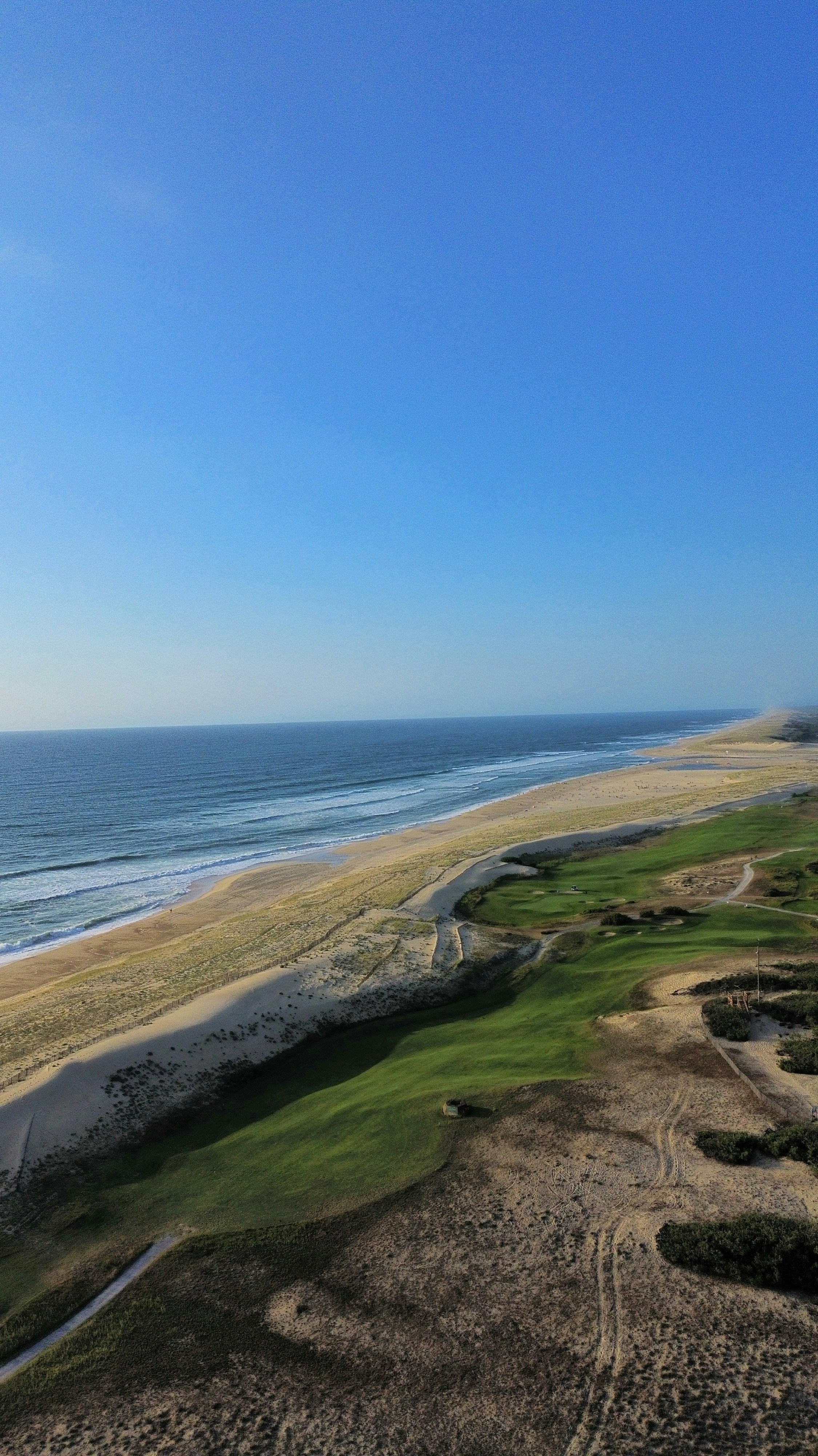 An aerial view of a golf course near the ocean