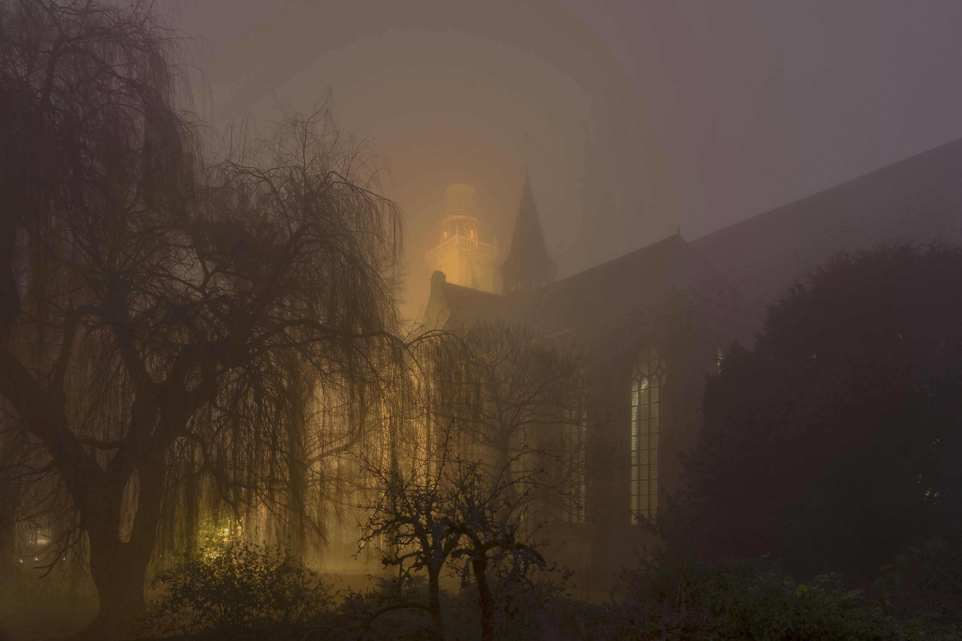 A foggy night with a church in the background