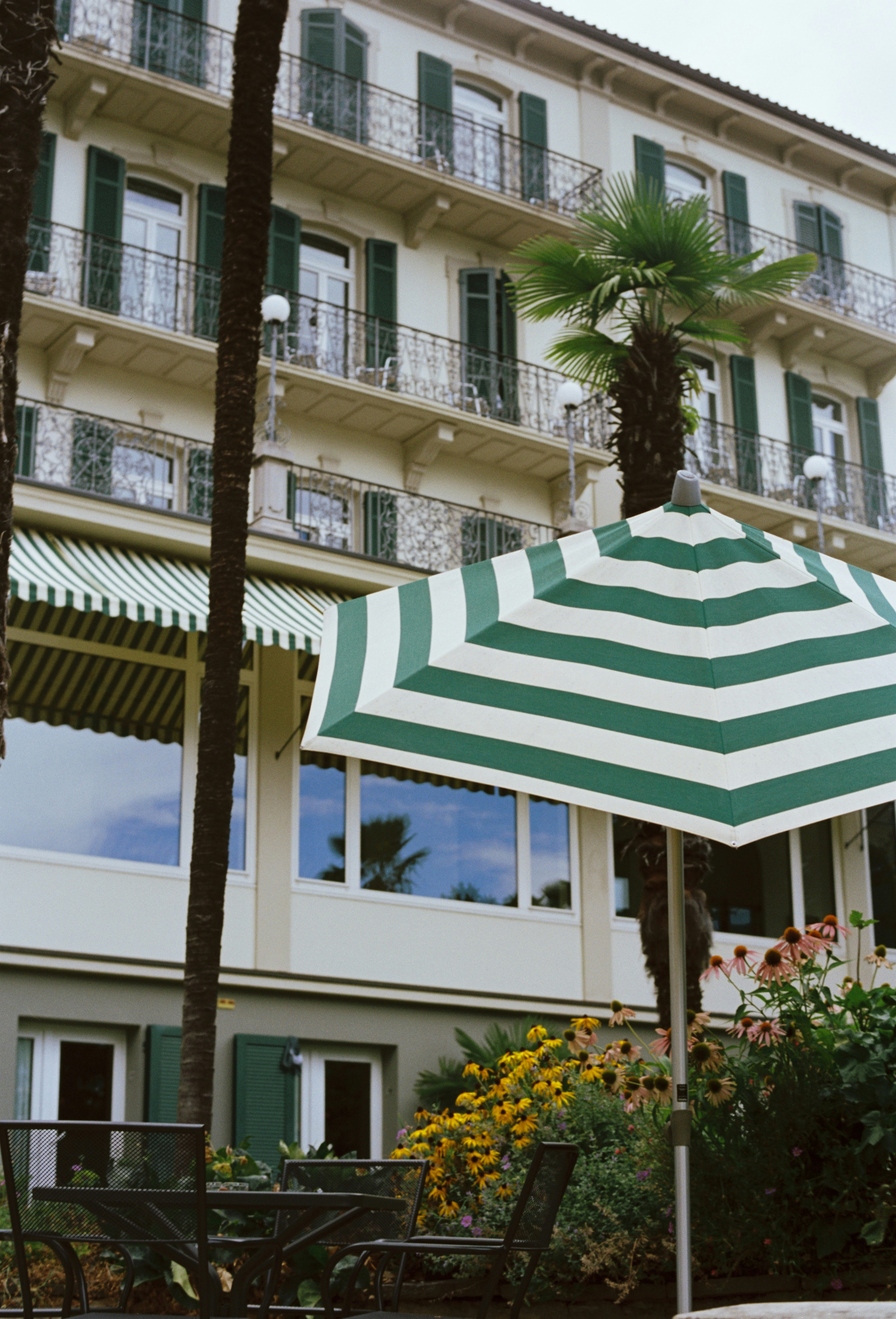 A large green and white umbrella sitting in front of a building