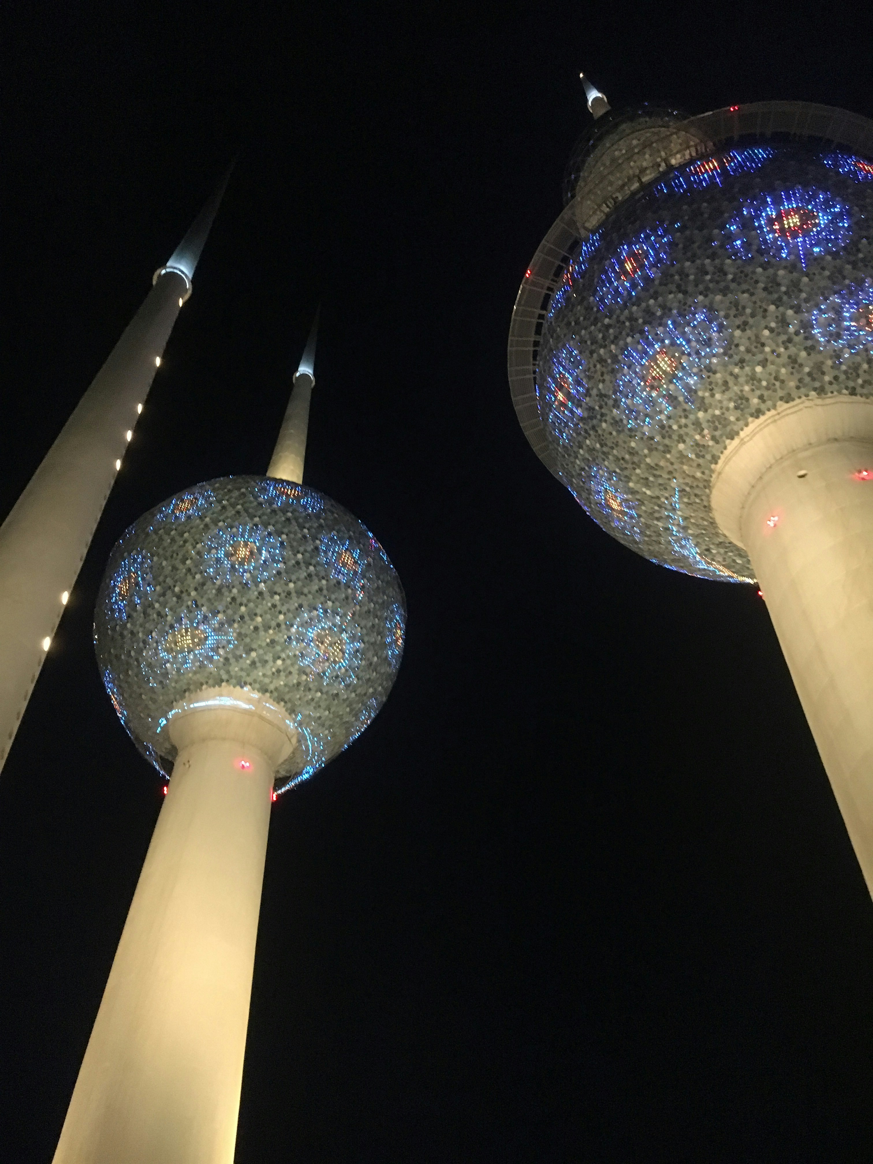 A couple of tall buildings with lights on them