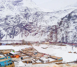 A snow covered mountain with a village in the foreground