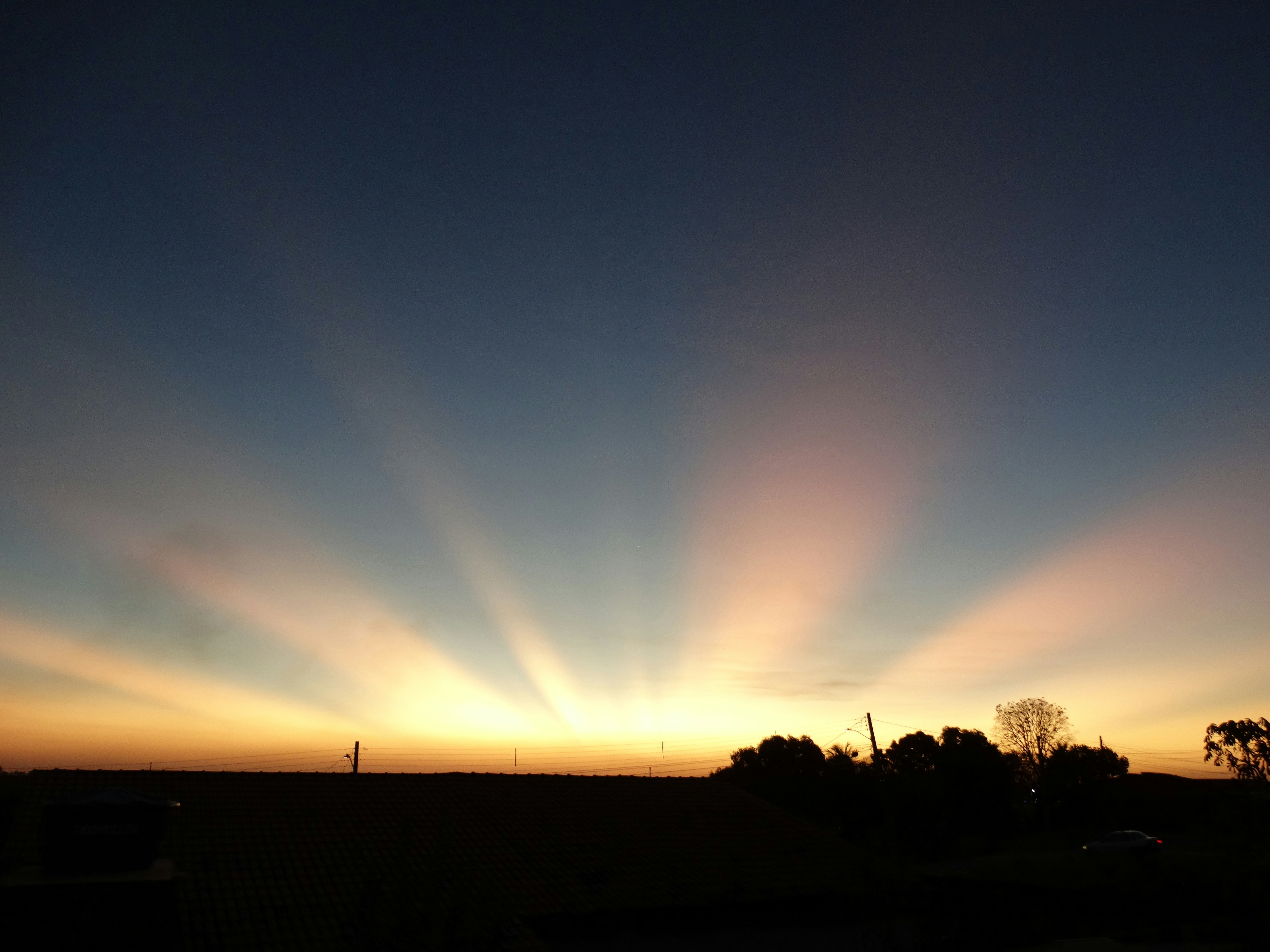 The sun is setting in the sky over a field
