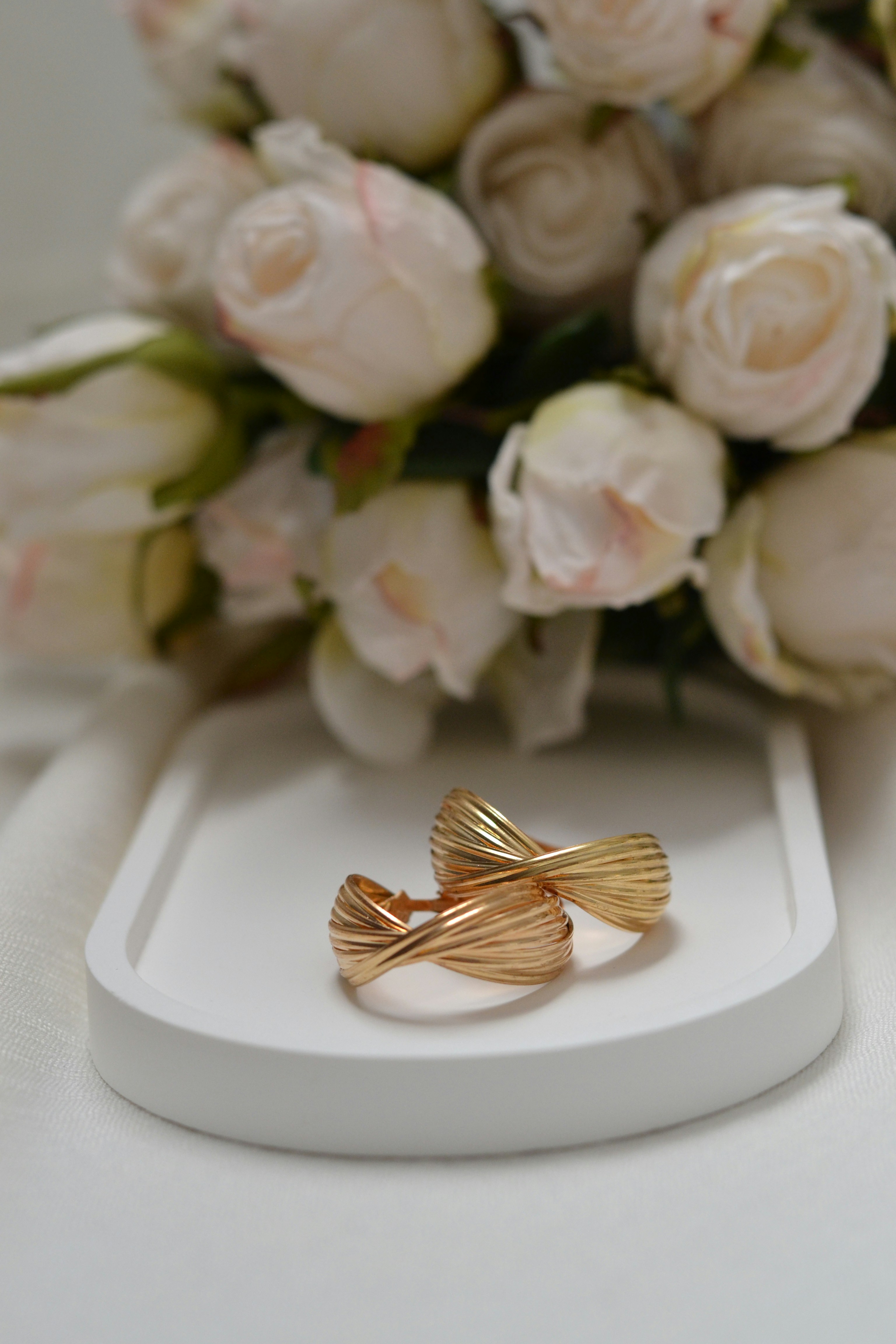 A bouquet of flowers sitting next to a gold ring