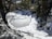 A frozen lake surrounded by trees and snow