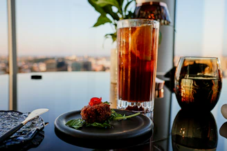A table with a glass of tea and a plate of food