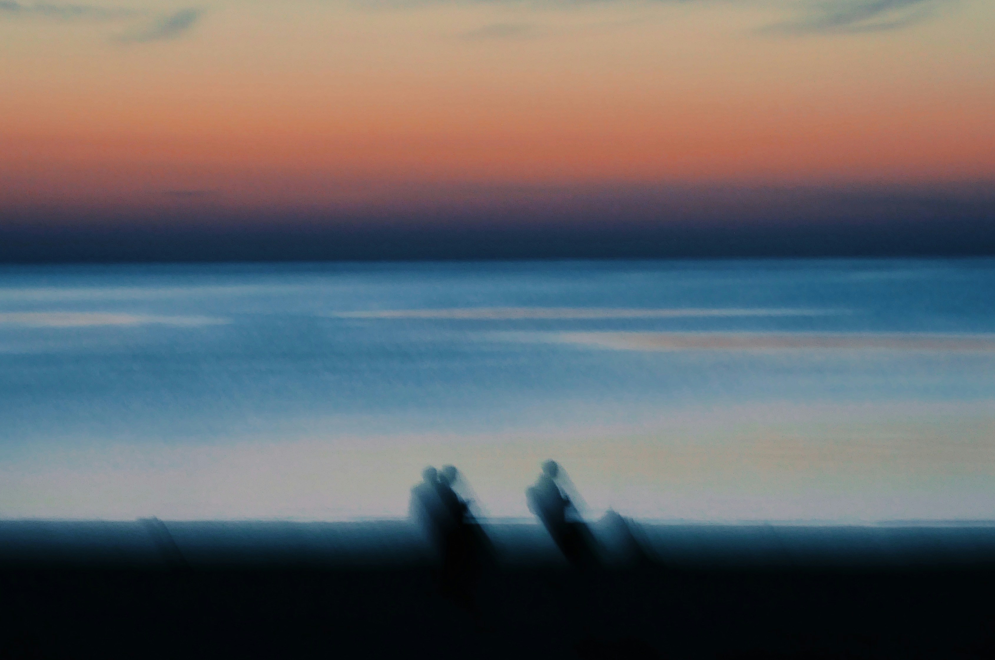 Una foto borrosa de dos personas caminando por la playa