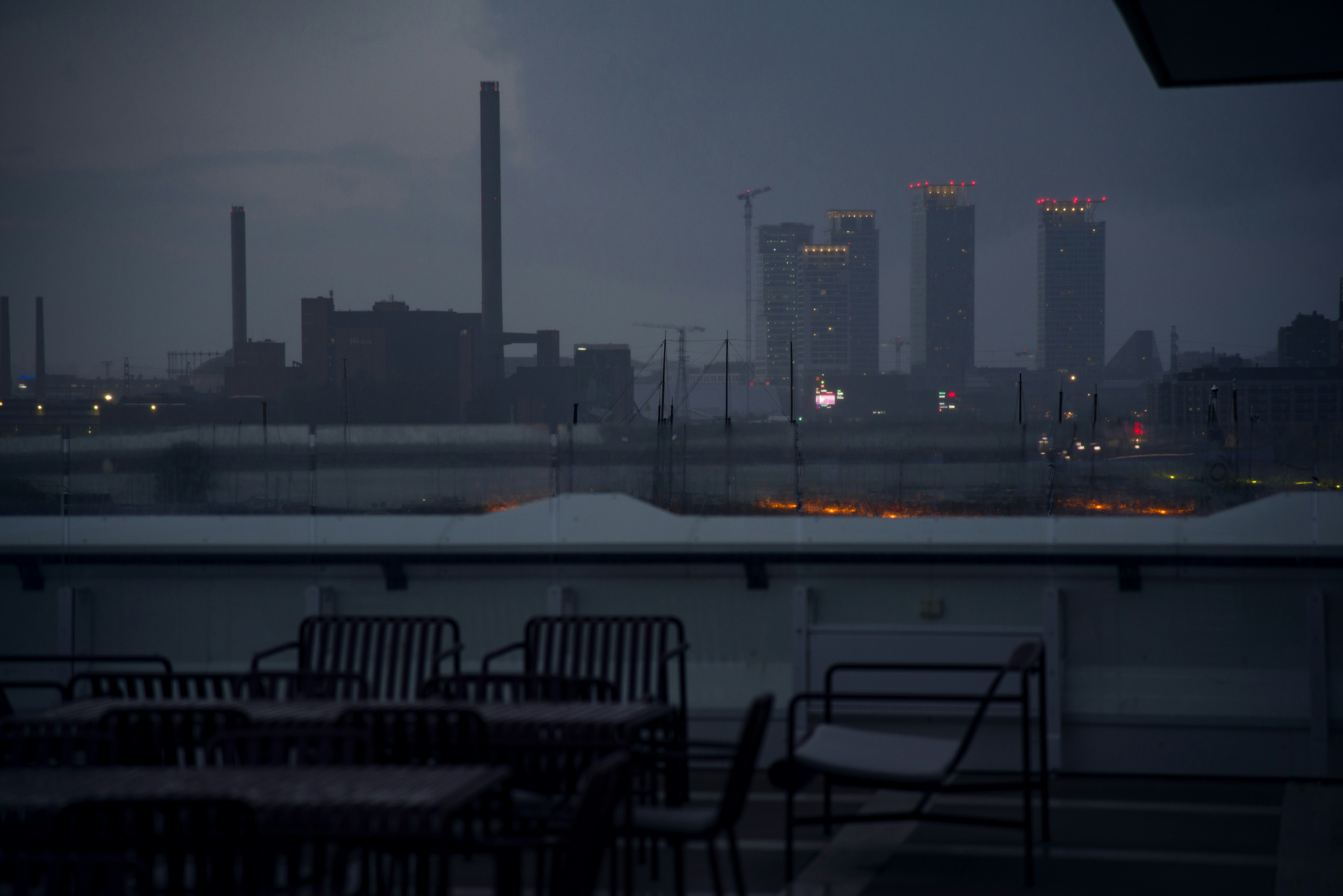 Rooftop restaurant tables at night above city lights
