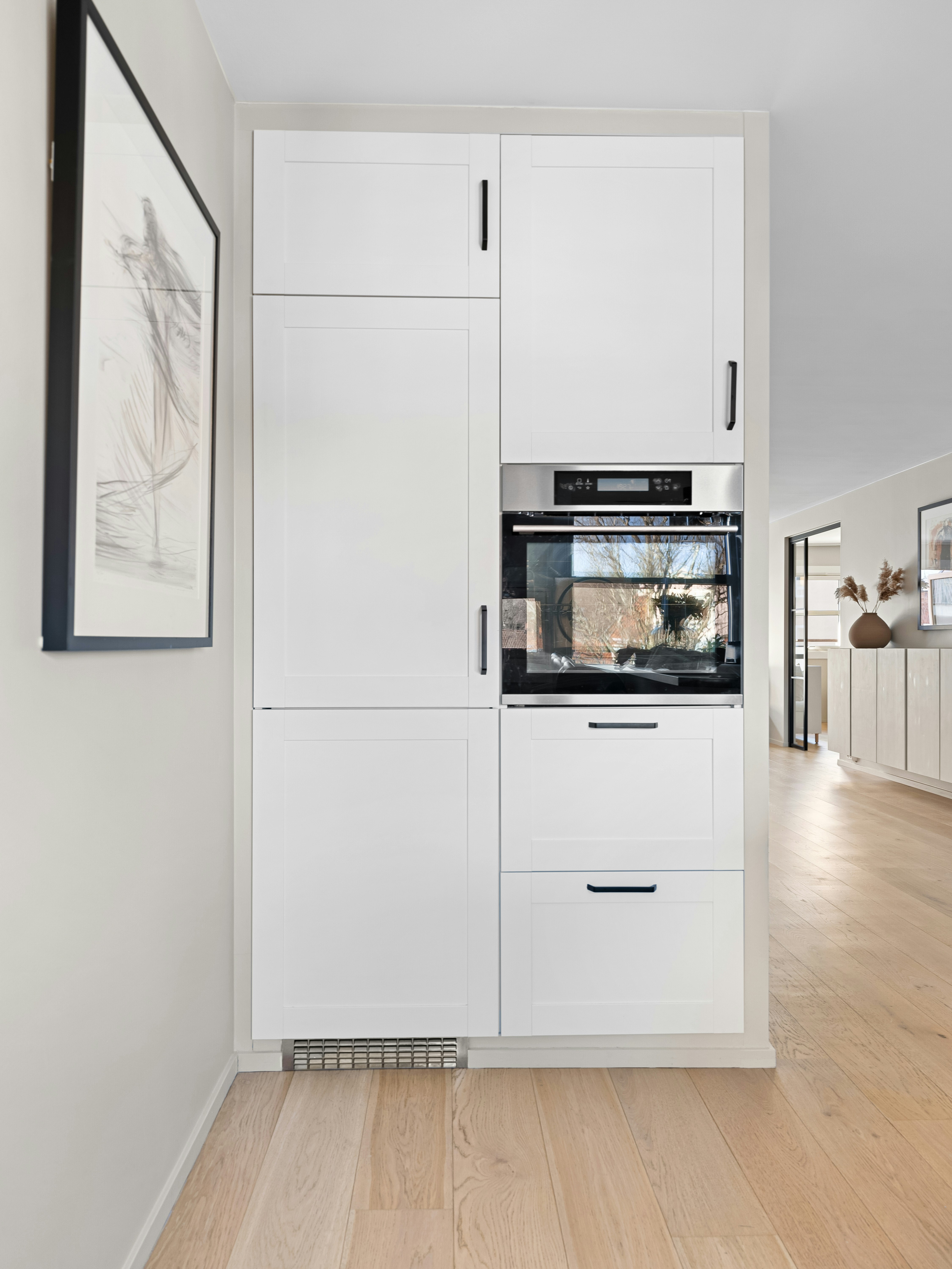 Modern kitchen with drywall partition and built-in storage, clean white finish