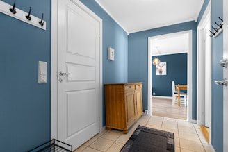 A hallway with blue walls and white doors