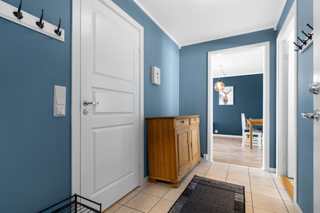 A hallway with blue walls and white doors