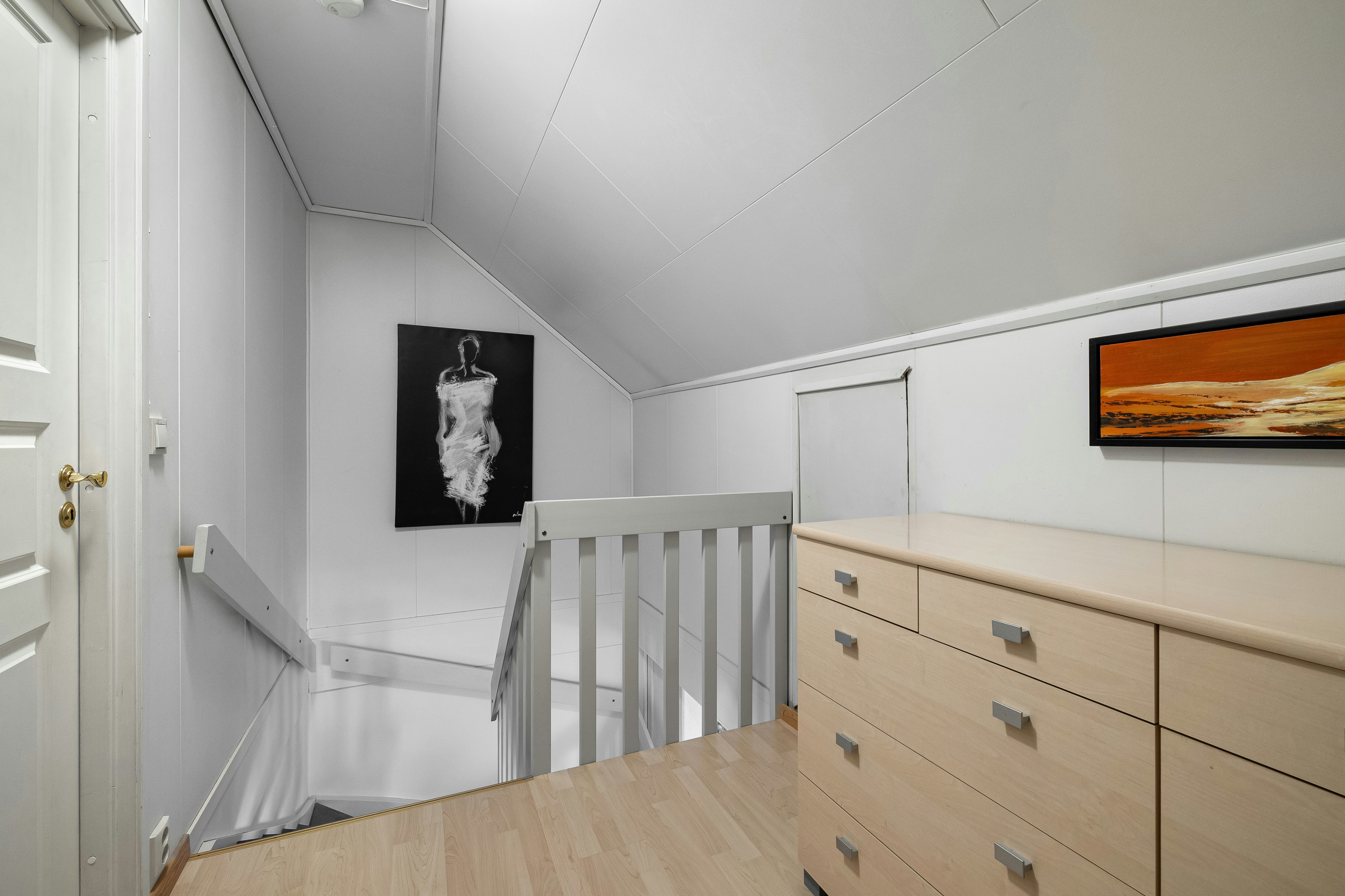 A room with a dresser and a picture on the wall