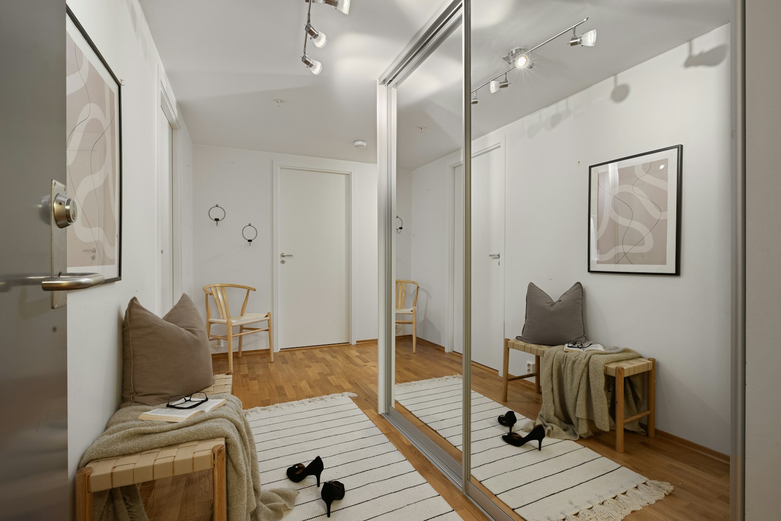 apartment hallway with mirrored closet doors bench and rug