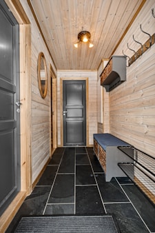 A hallway with a bench and a mirror