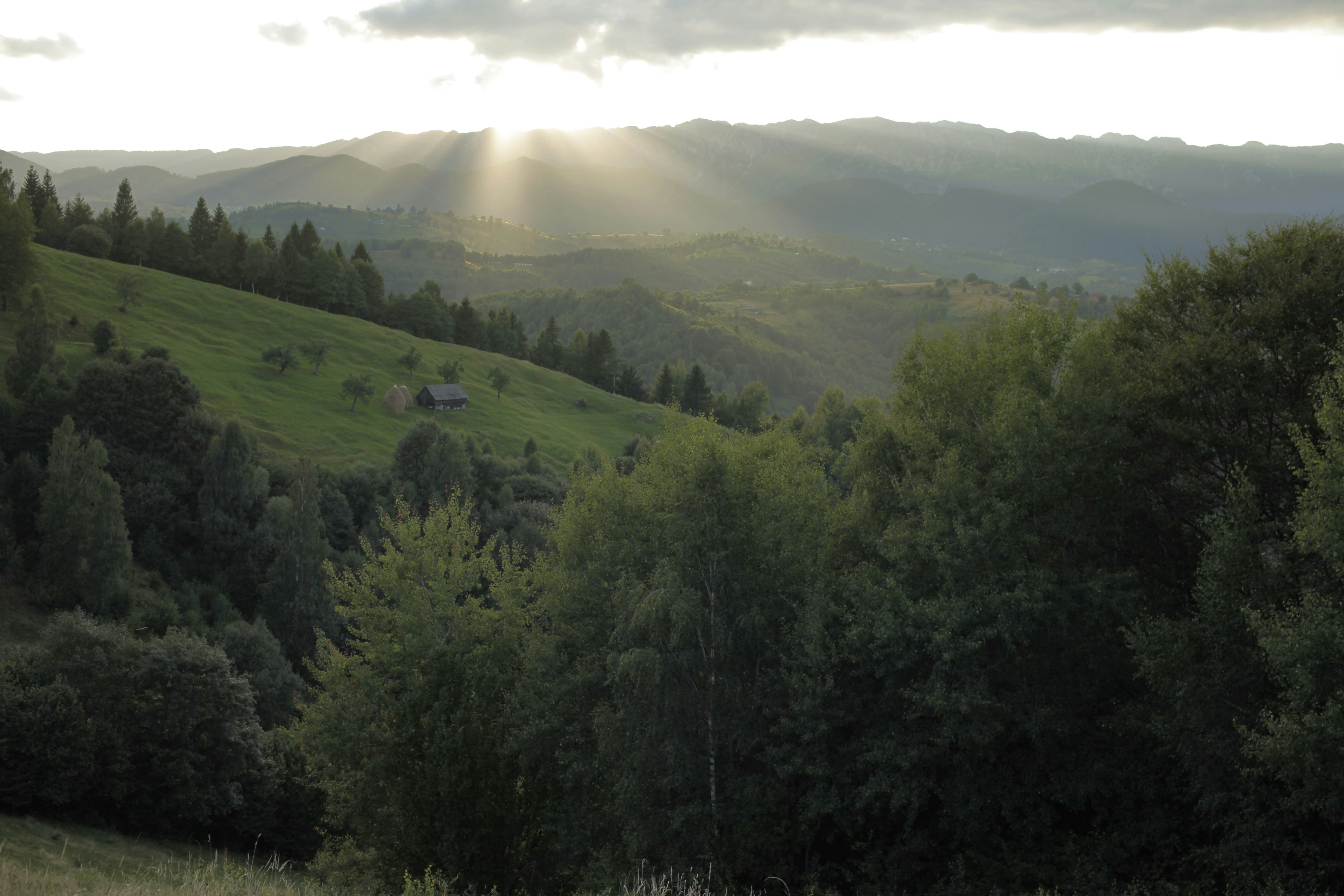 The sun is shining through the clouds over the mountains