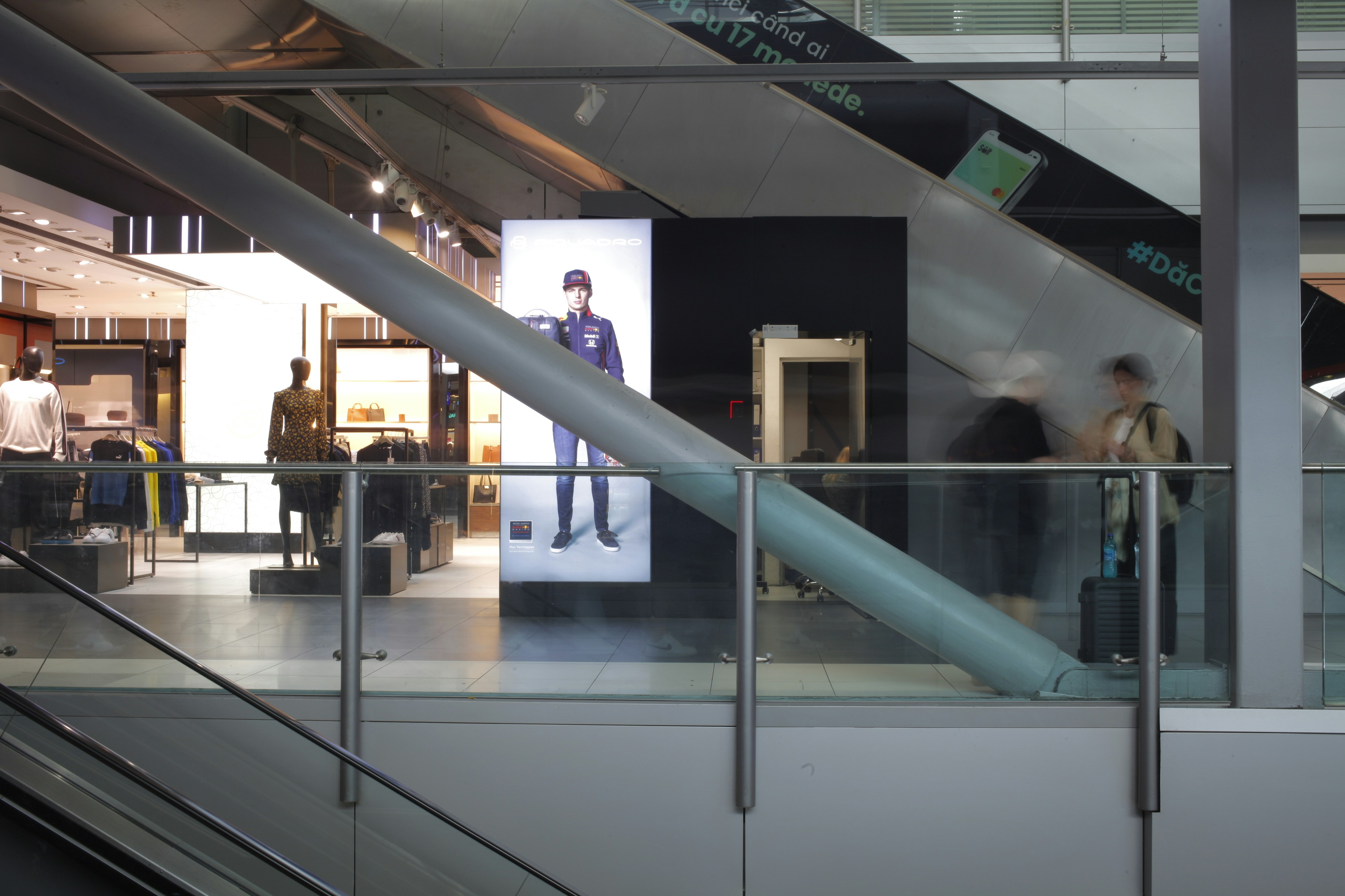 An escalator in a building with people walking up and down it