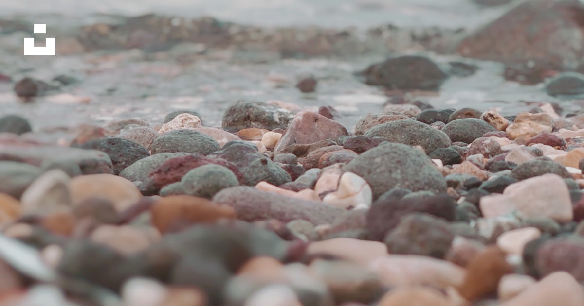 A blurry photo of rocks and water on a beach photo – Free Sea Image on ...