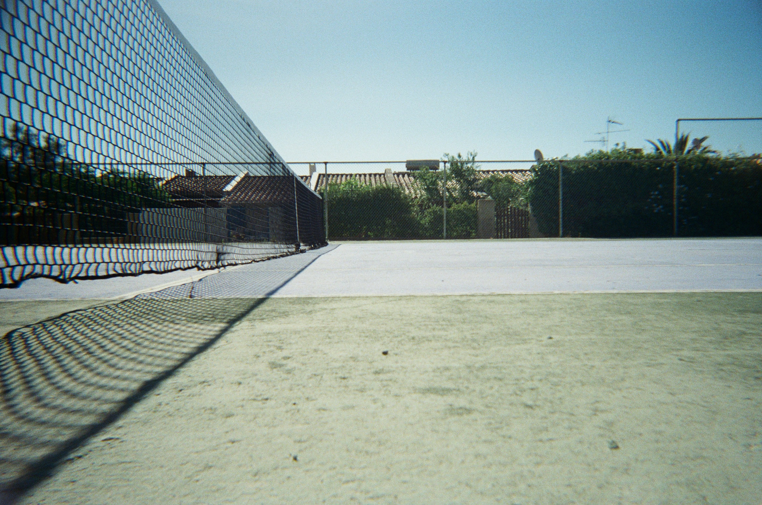 A tennis court with a tennis net in the background