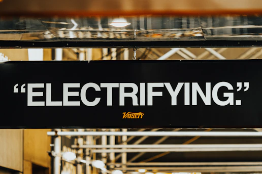 A sign that says electrifying hanging from a ceiling