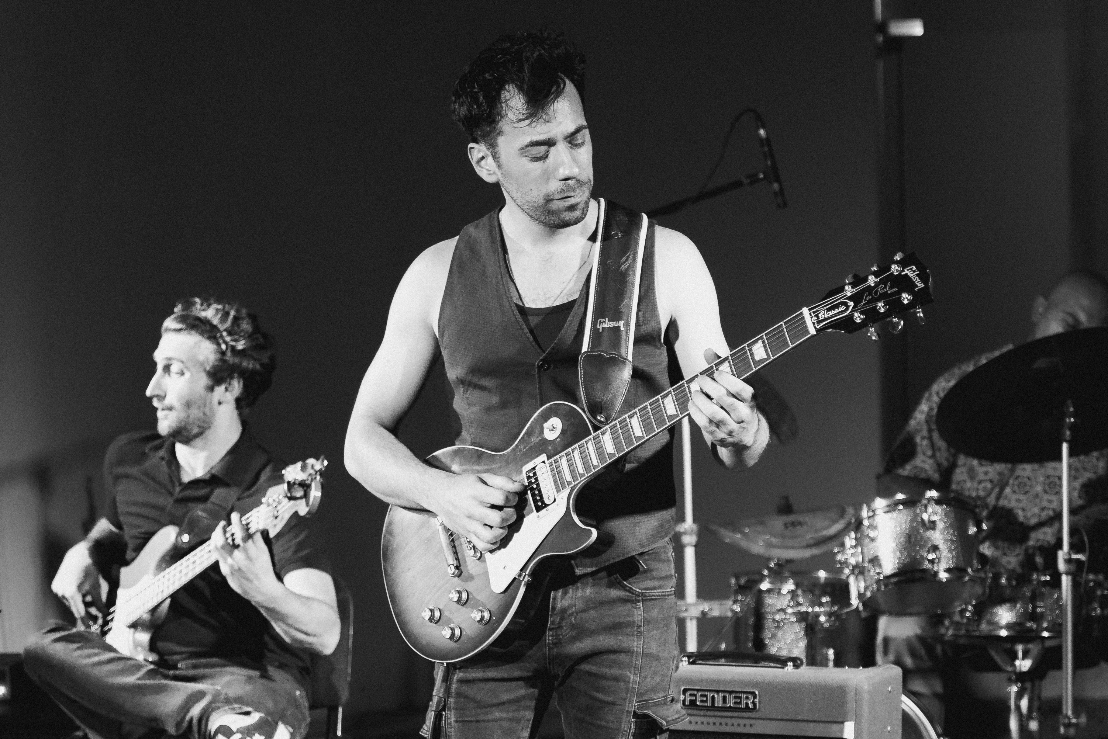 A group of men playing guitars on stage