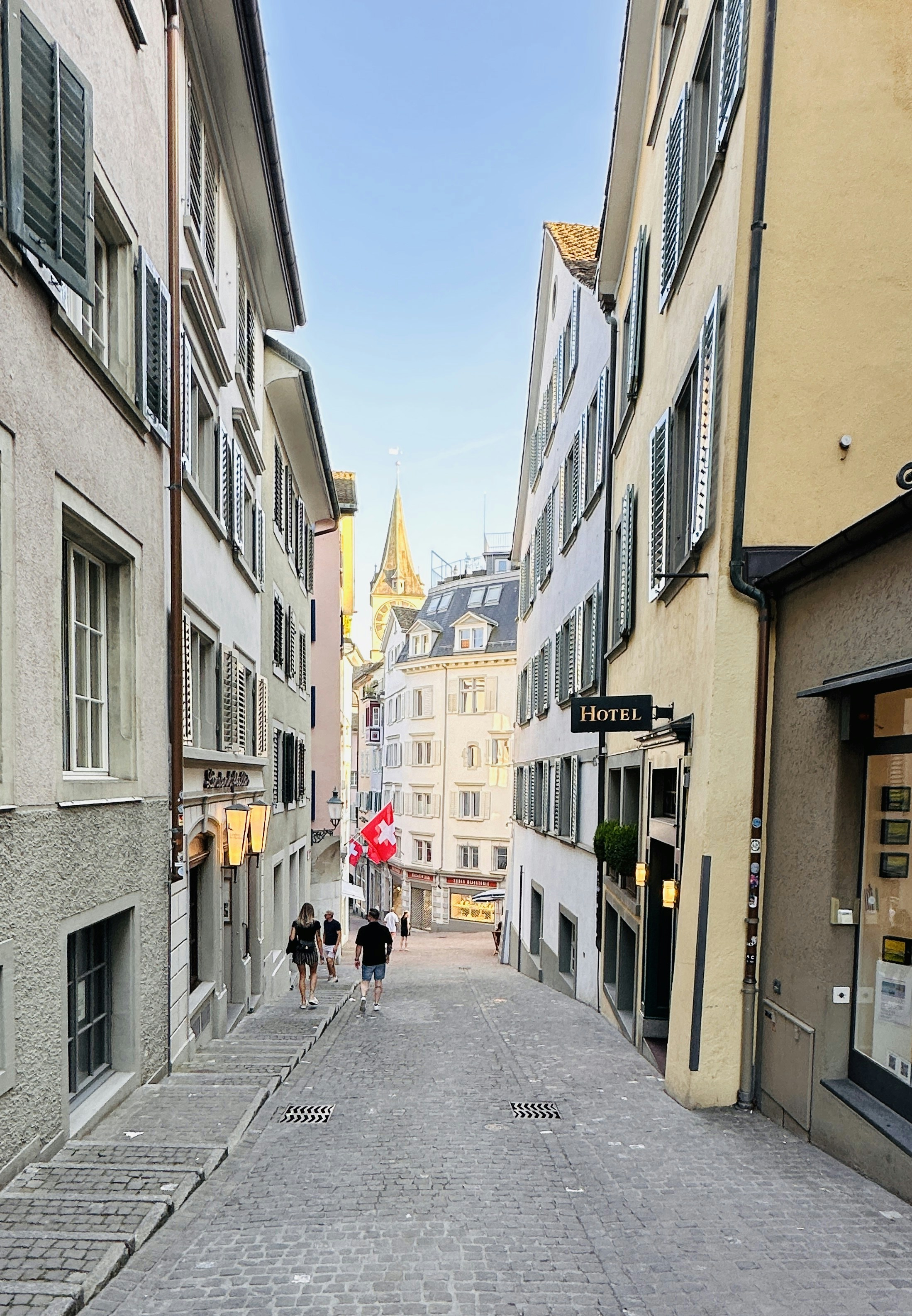 A narrow street with people walking down it
