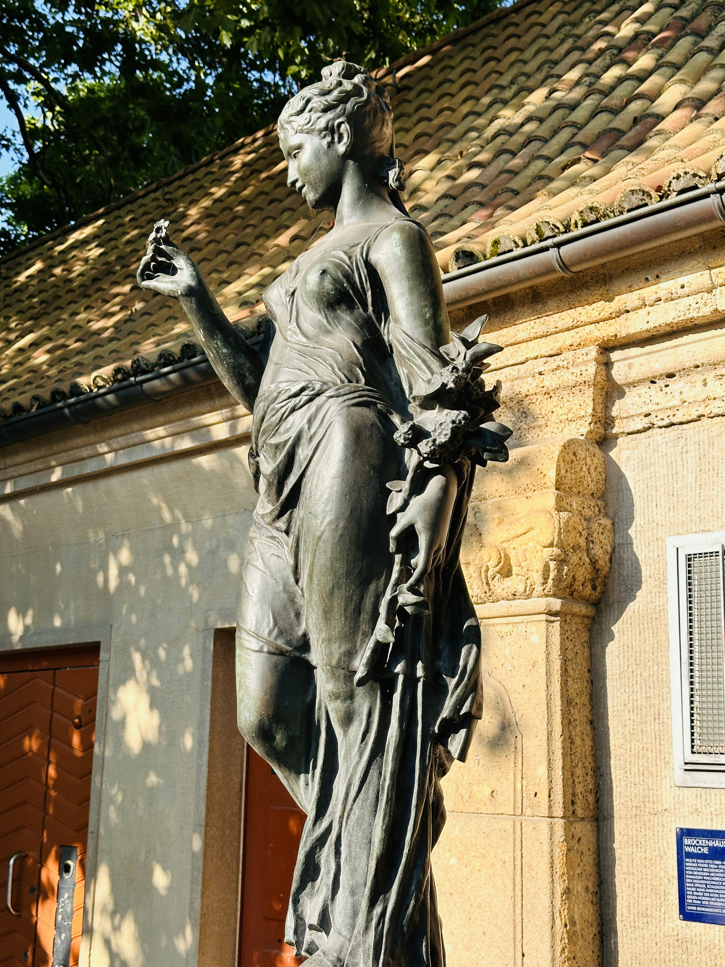 A statue of a woman in front of a building
