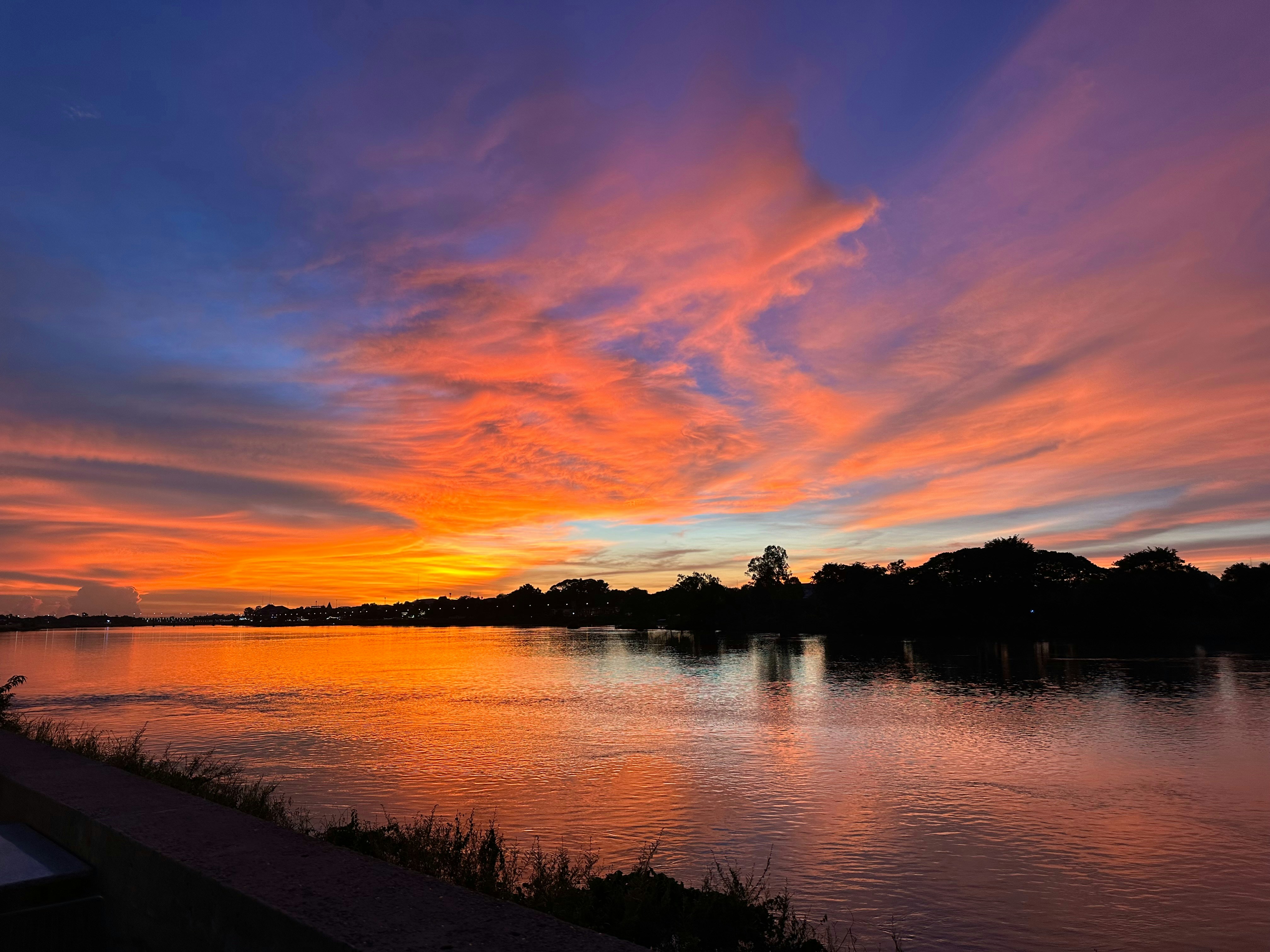 A beautiful sunset over a lake with clouds in the sky