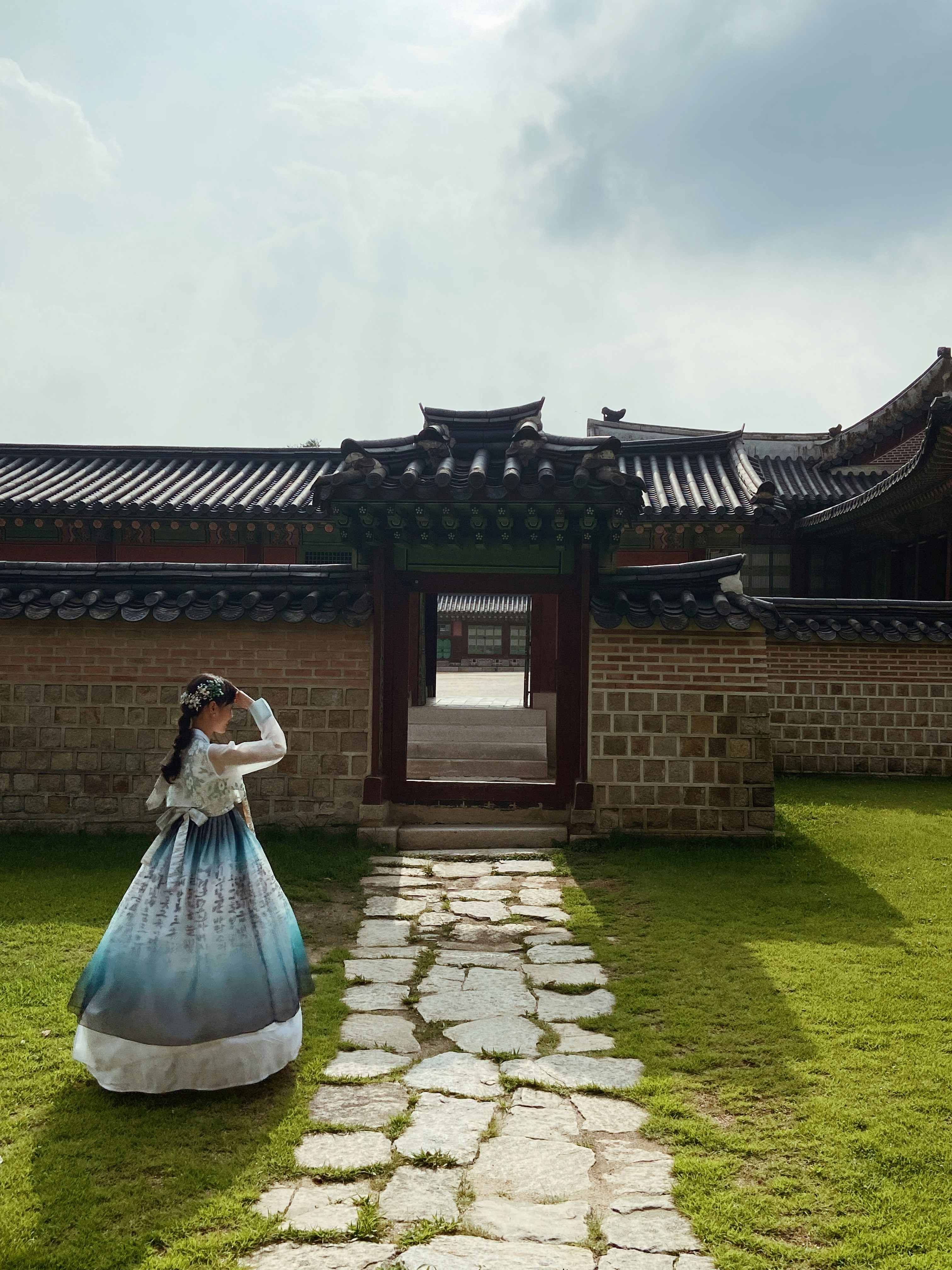 A woman in a blue dress standing in front of a building