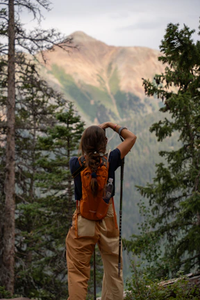 A man with a backpack standing on a mountain