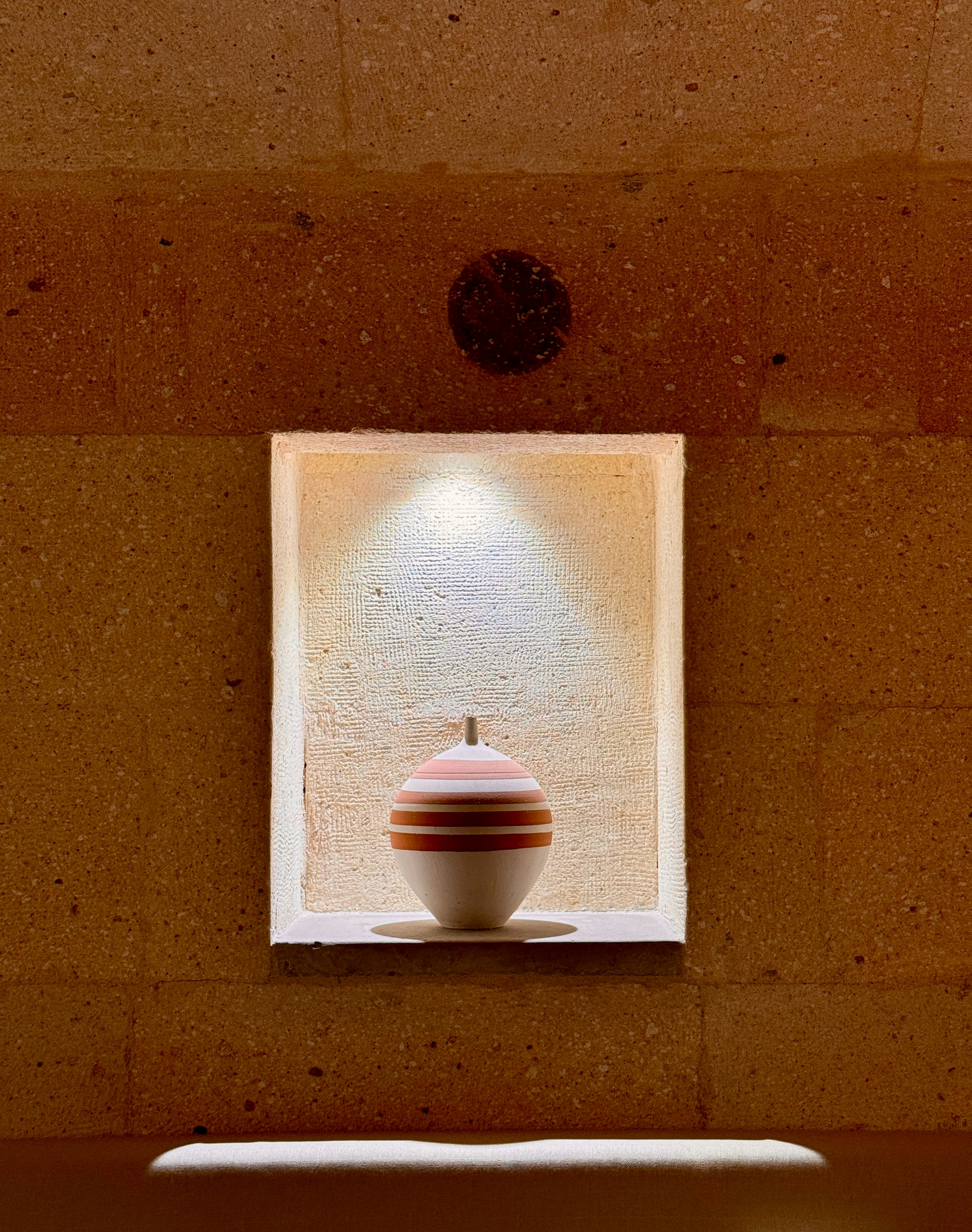 A white toilet sitting under a window in a bathroom