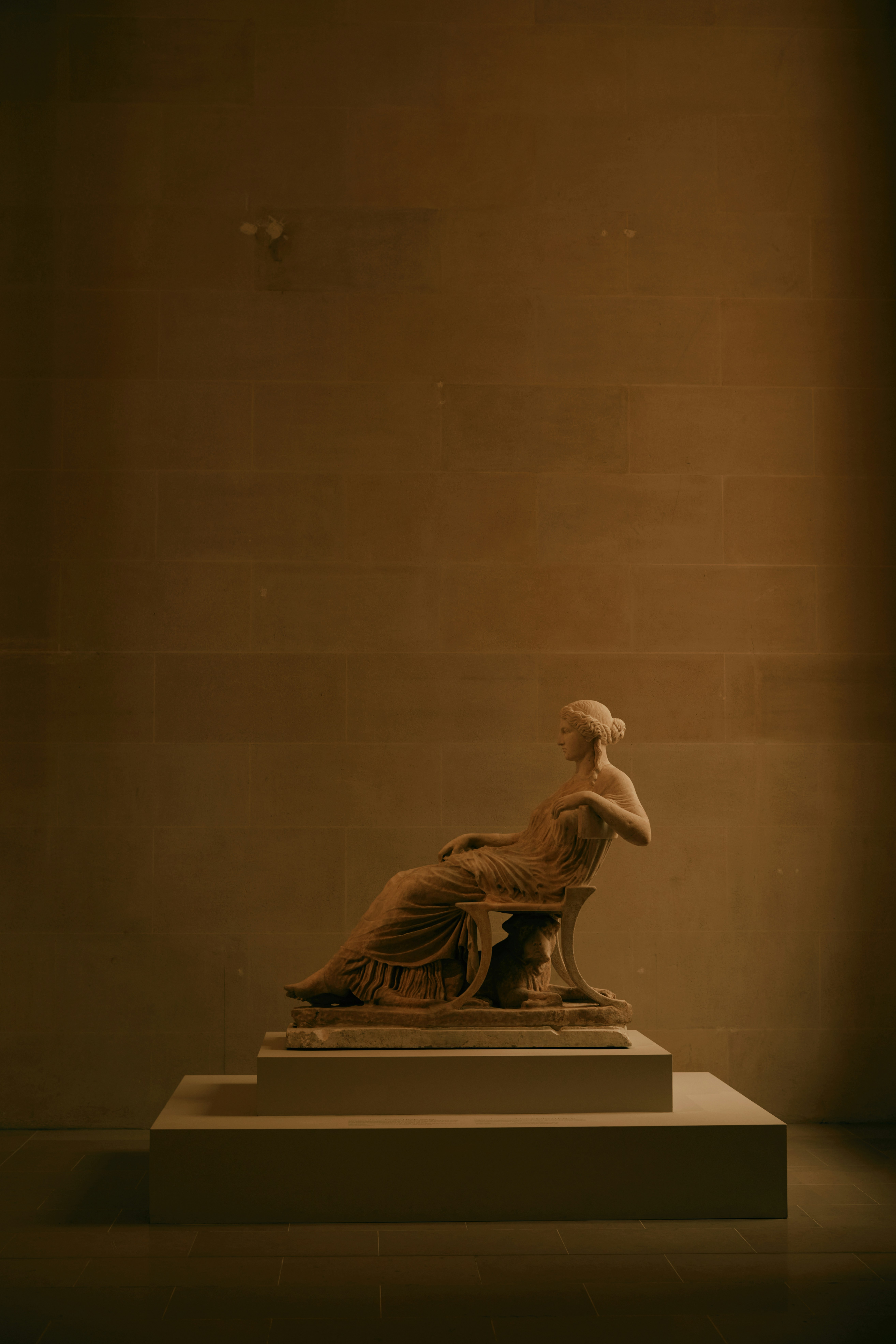 Uma escultura de uma mulher sentada em um pedestal