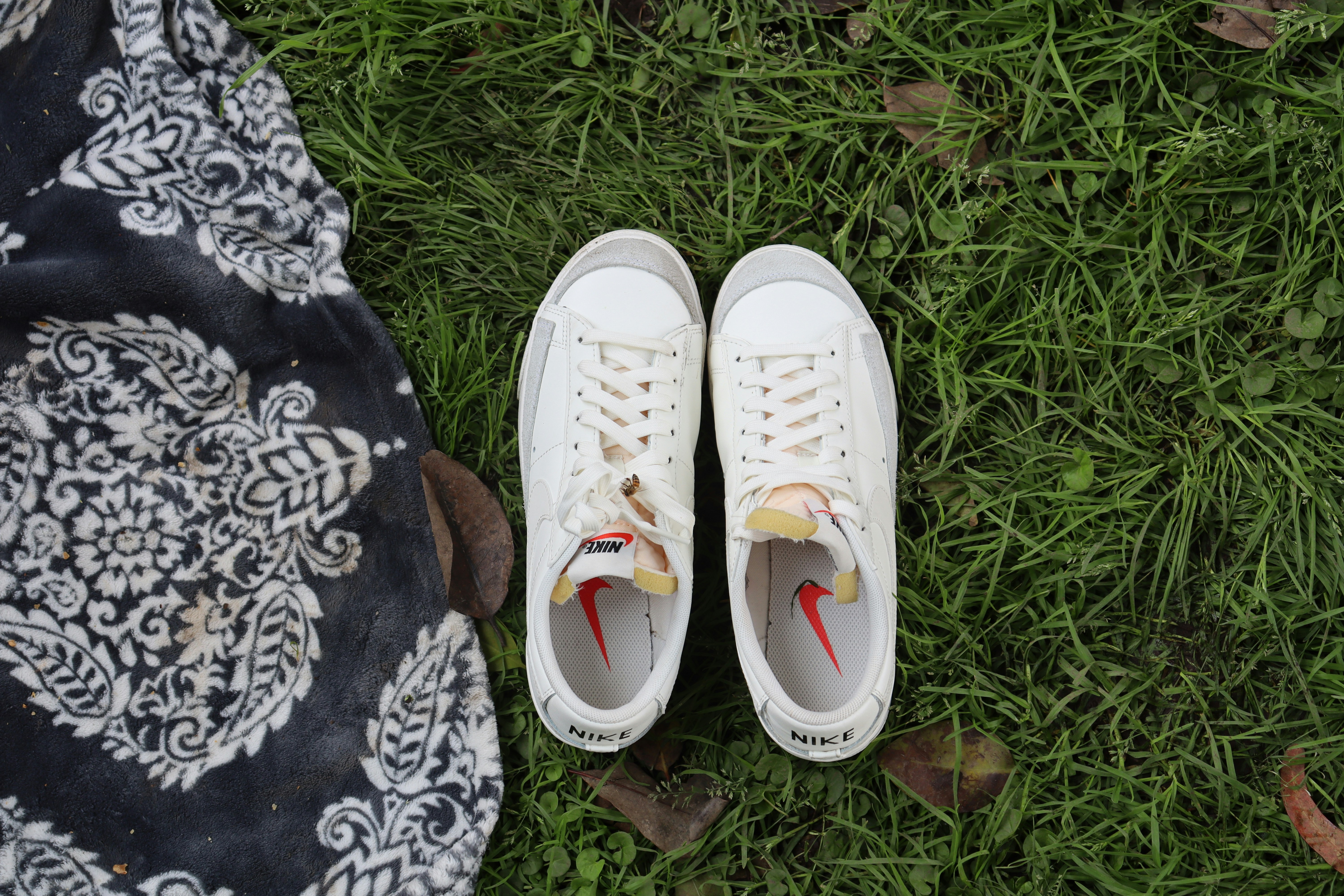 A pair of white shoes sitting on top of a lush green field