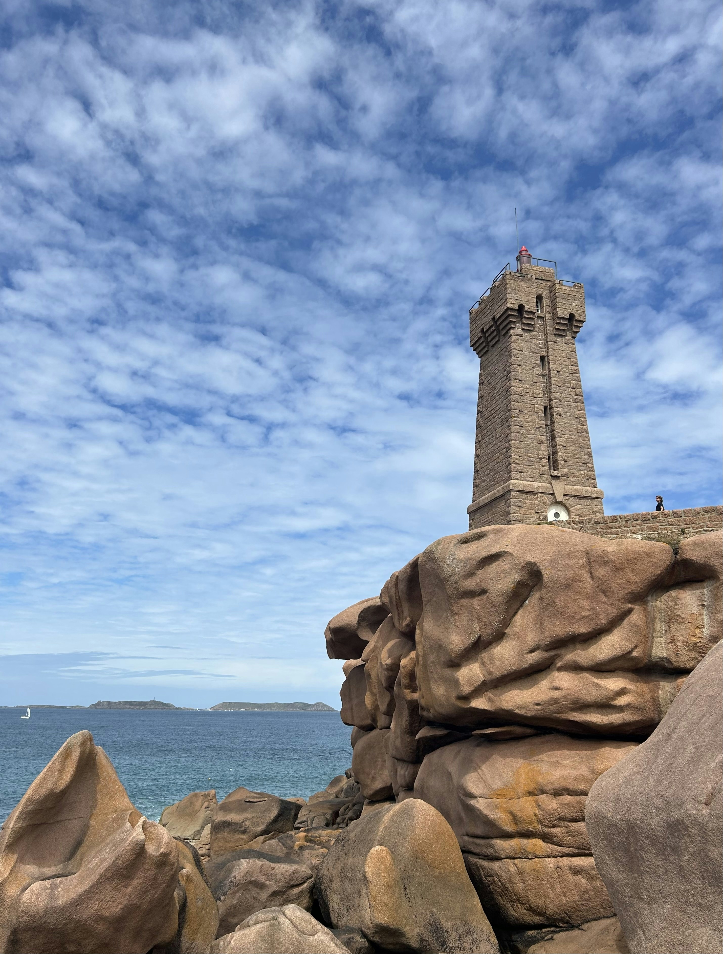 A lighthouse on top of a rock near the ocean