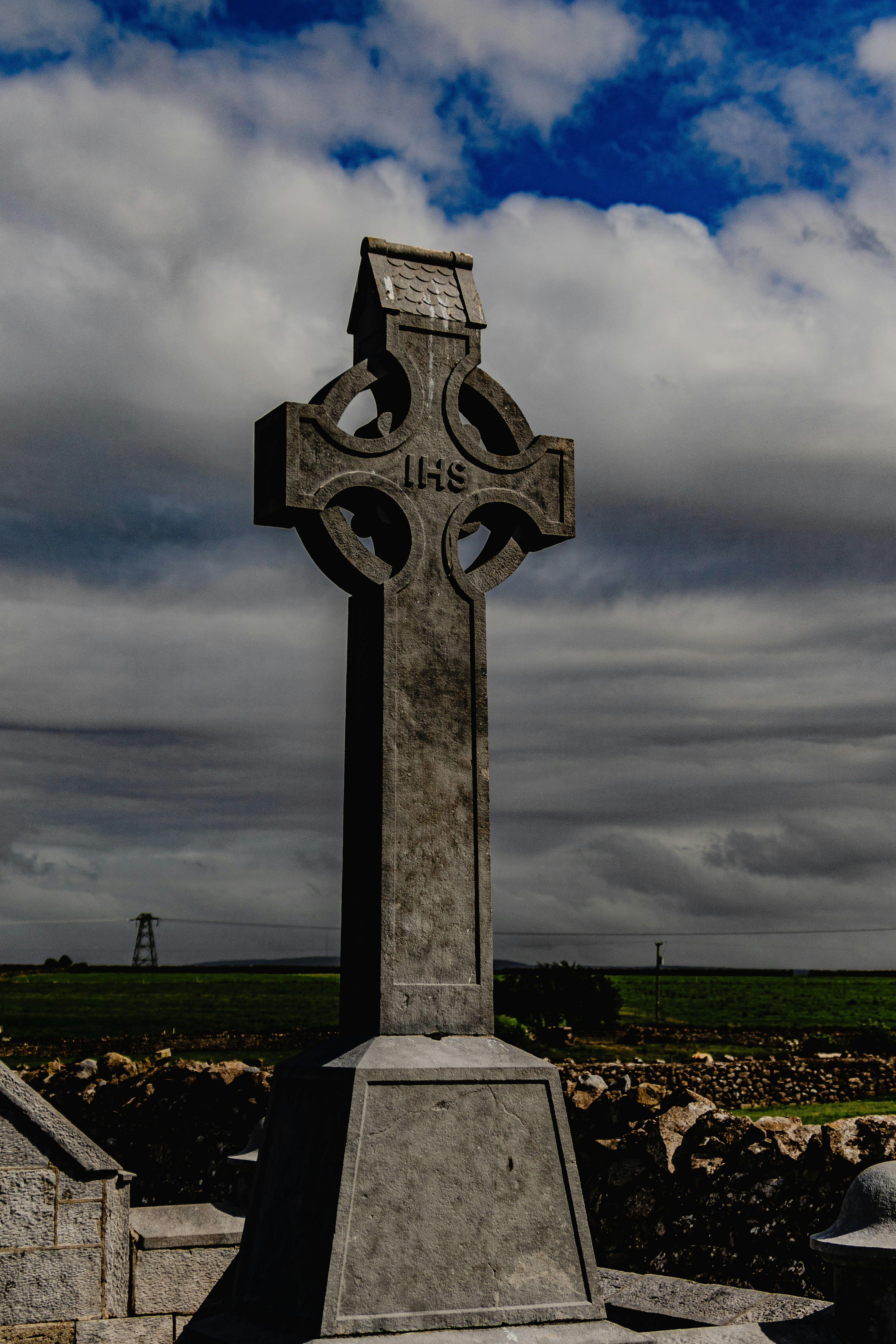 A large stone cross sitting in the middle of a field