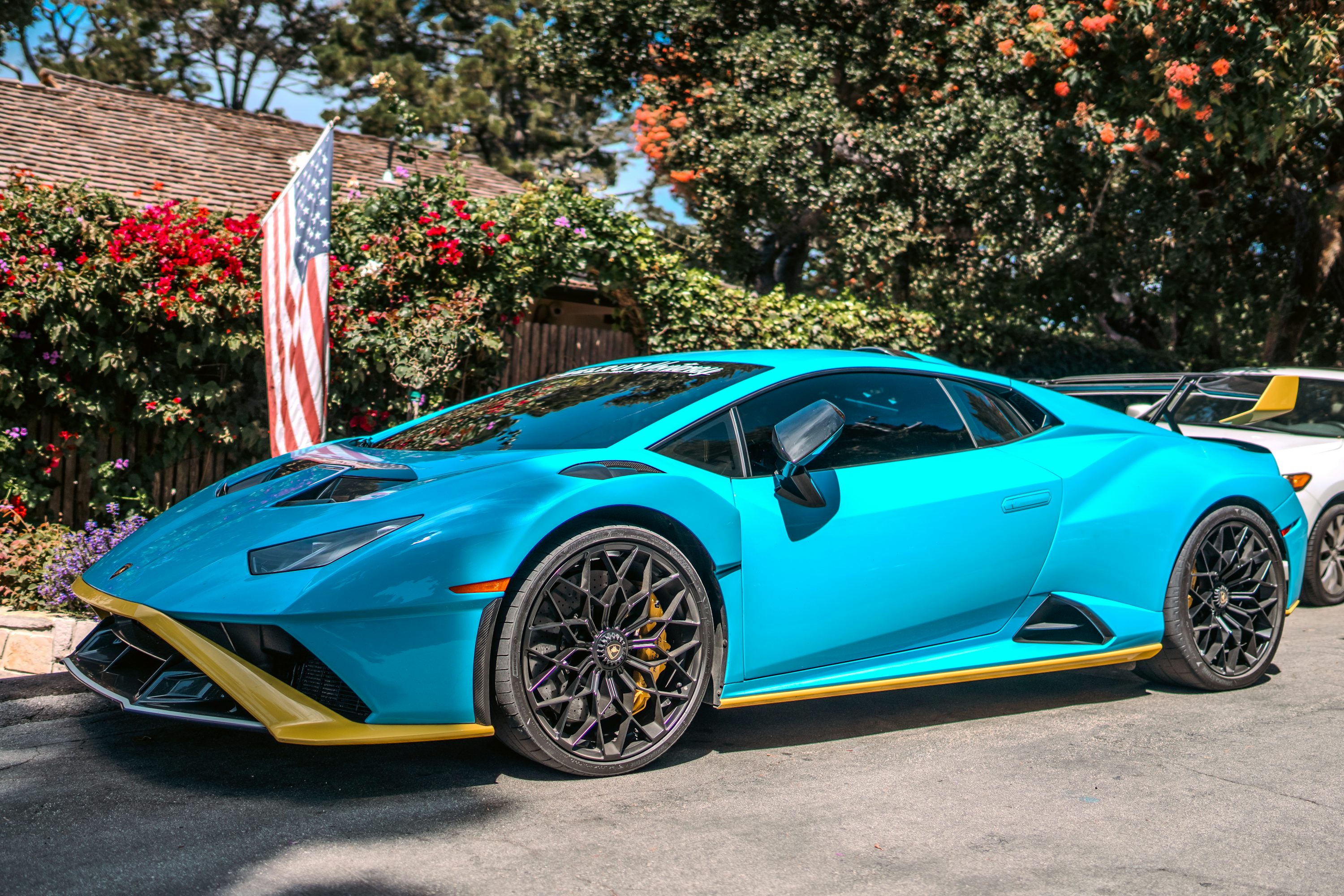 A blue and yellow sports car parked in front of a house