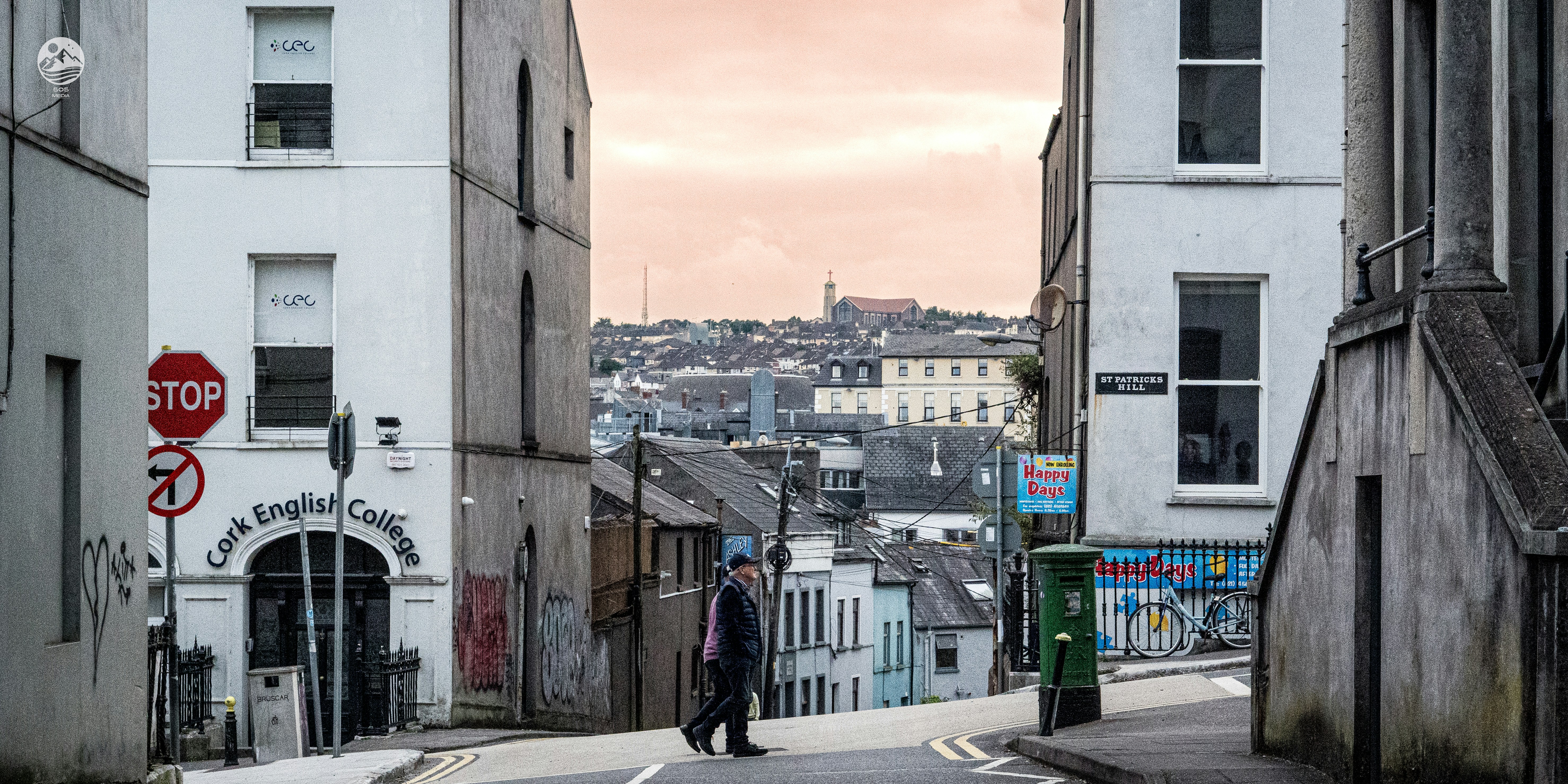 Un hombre caminando por una calle junto a edificios altos